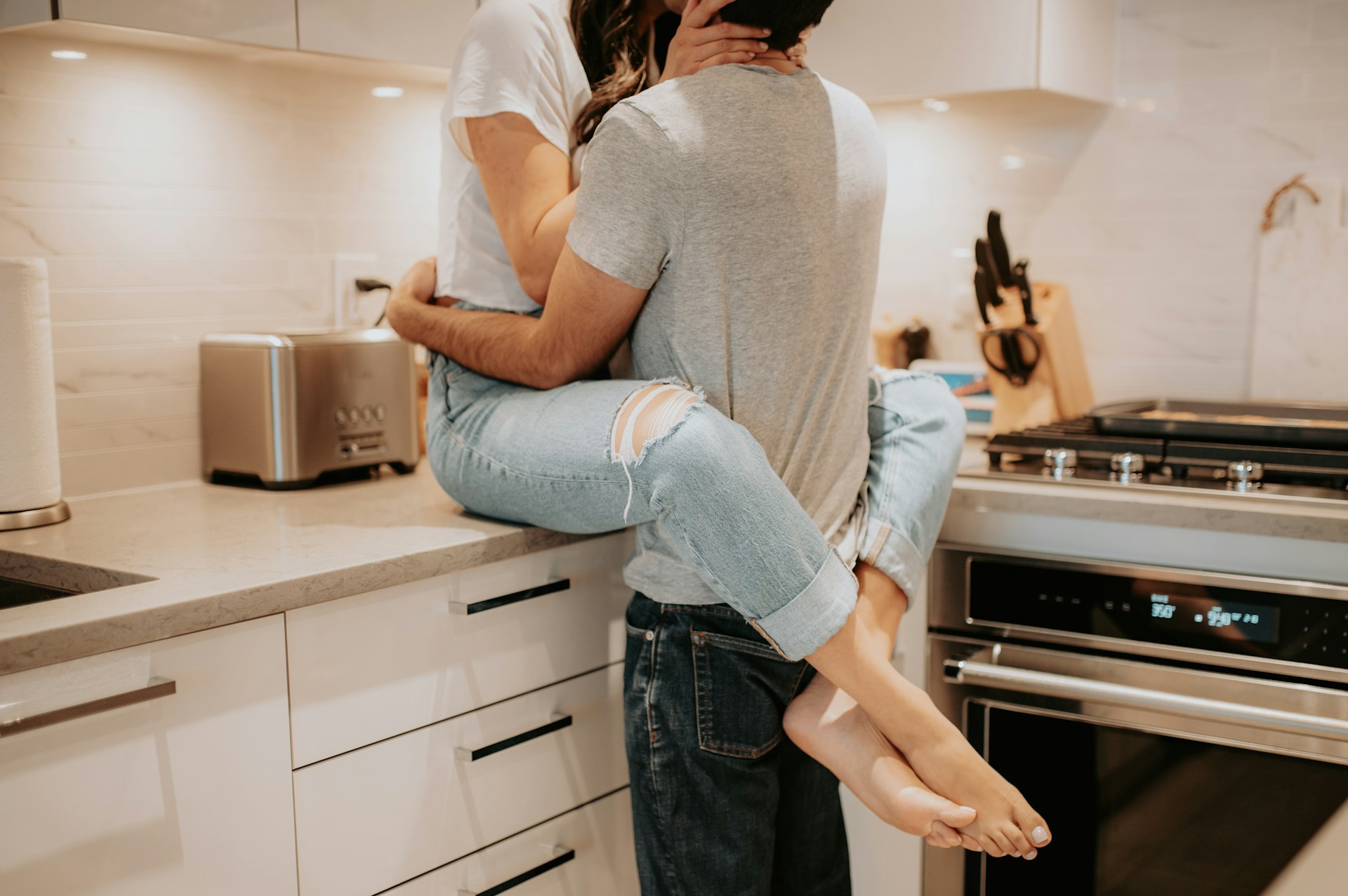 Una pareja romántica abrazándose en la cocina | Fuente: Unsplash