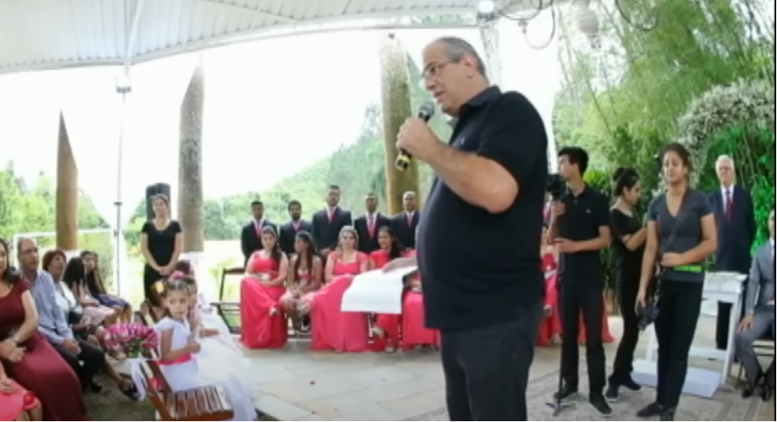 Invitados a la boda reunidos alrededor de una persona con un micrófono | Fuente: YouTube/SP no Ar