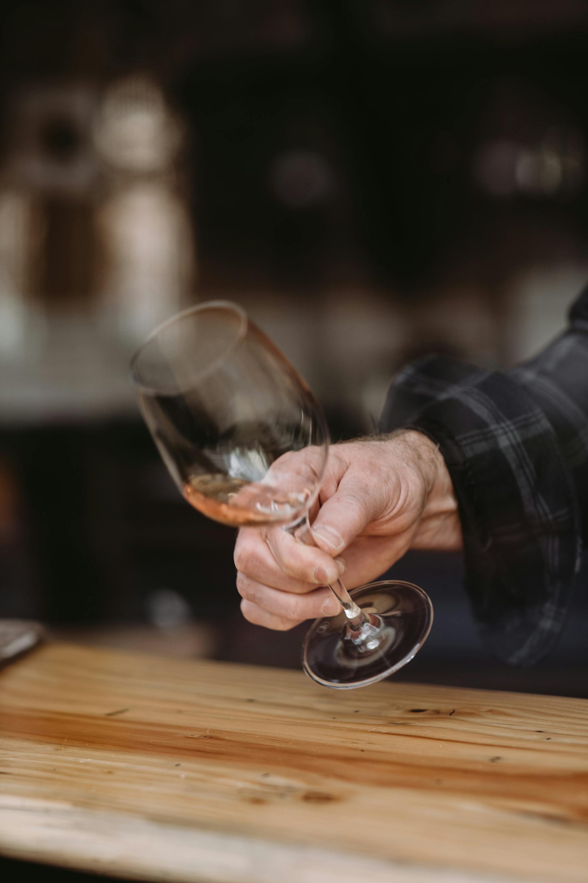 La mano de un hombre sosteniendo un vaso de vino | Fuente: Pexels