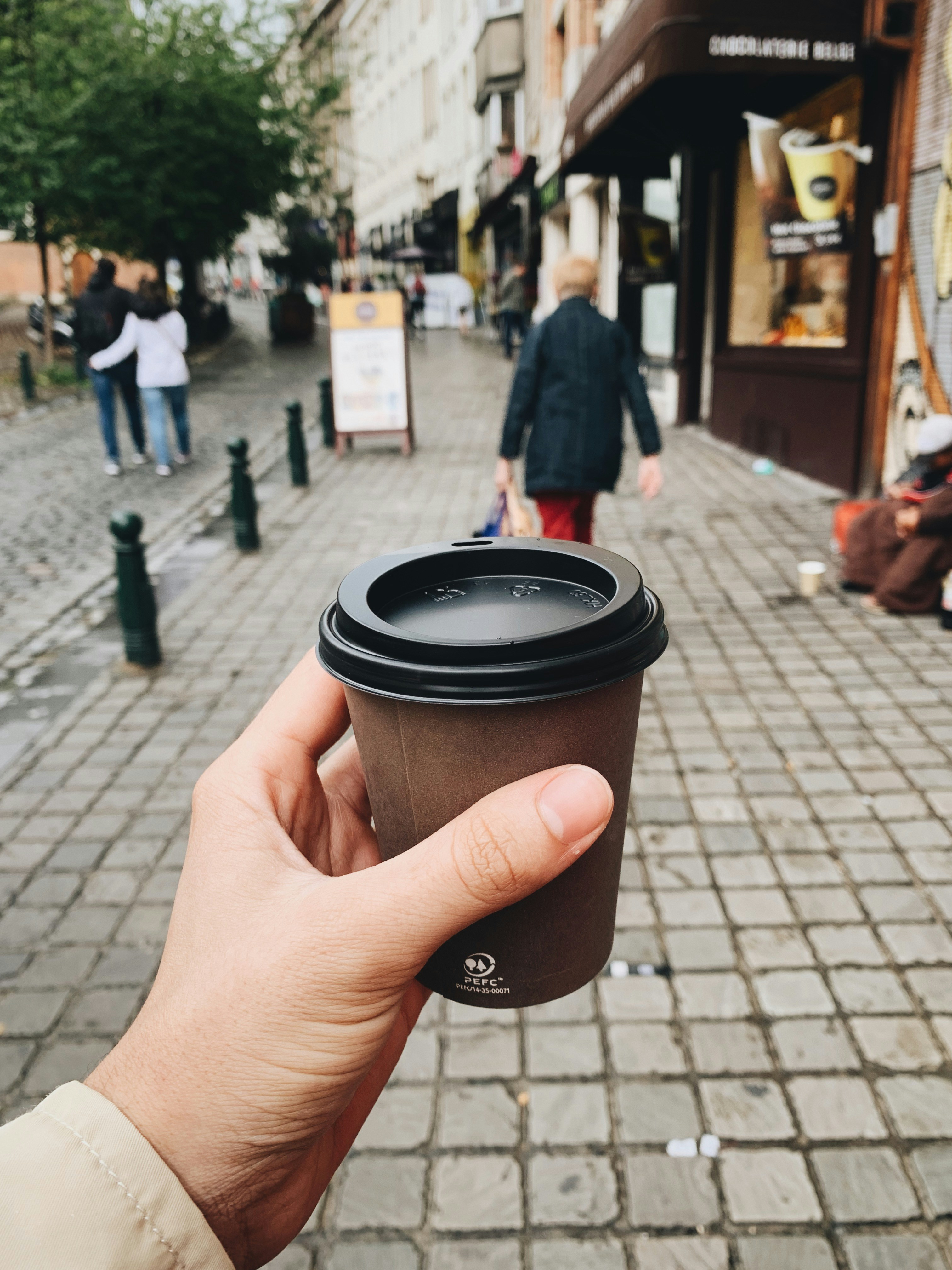 Una persona con una taza de café para llevar | Fuente: Unsplash
