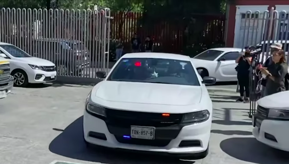 Un coche oficial transporta a los músicos para declarar. | Foto: YouTube/Grupo Fórmula