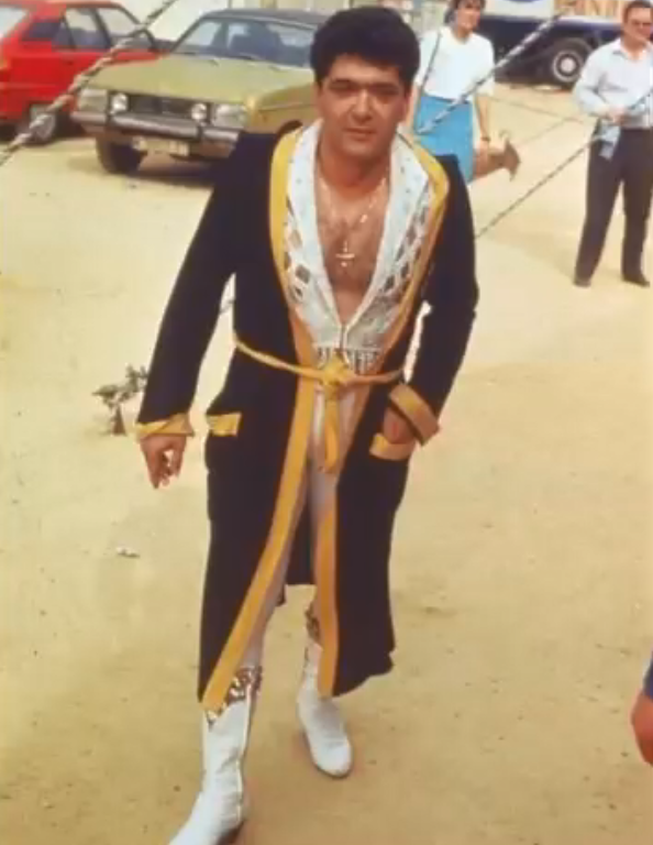 Ángel Cristo luciendo una bata negra con dorado y unas botas blancas | Fuente: Instagram/angelcristojr