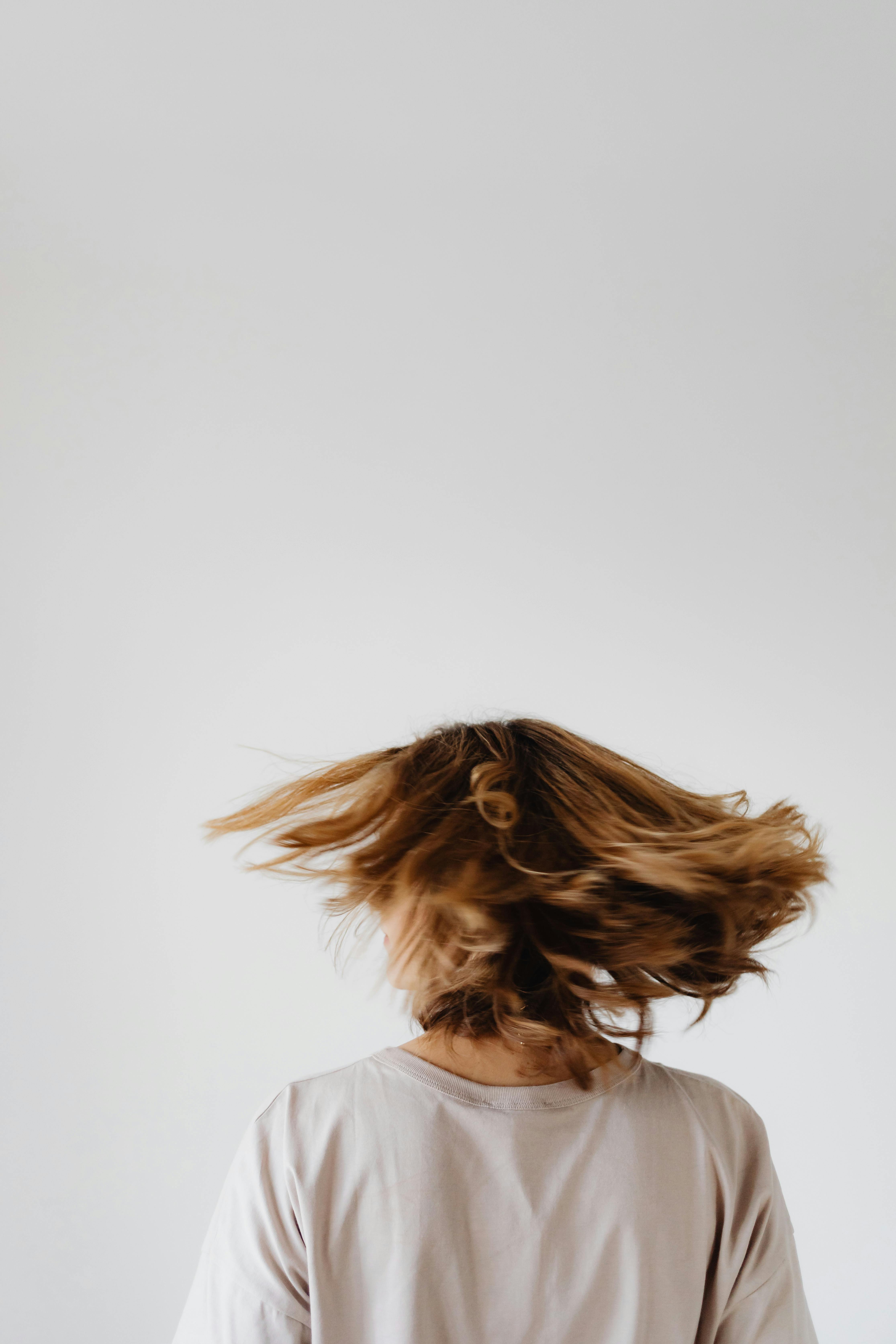 Una mujer revolviéndose el pelo | Fuente: Pexels