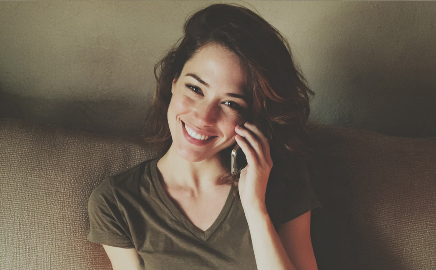 Una mujer sonriente hablando por teléfono | Fuente: Midjourney