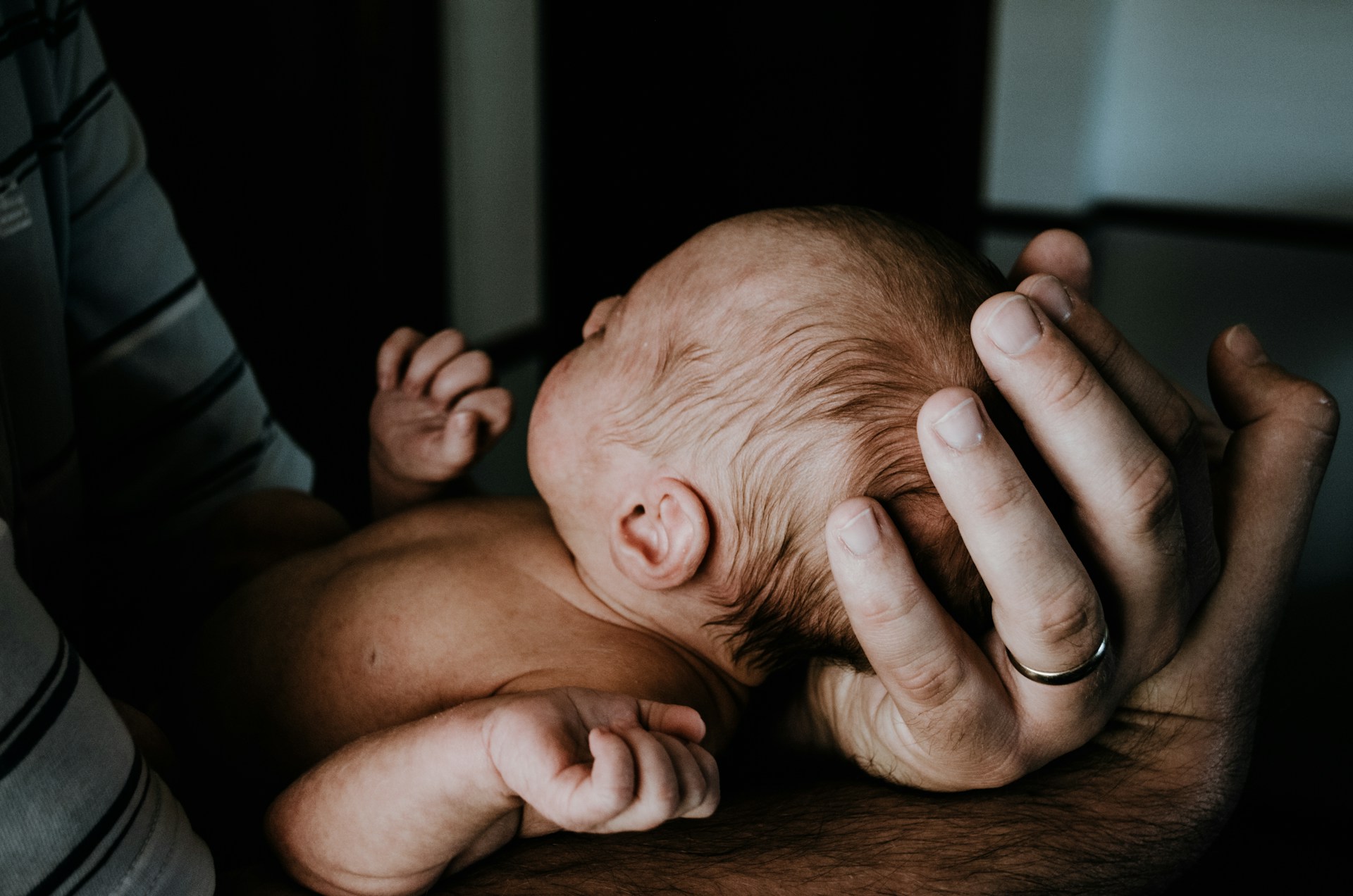 Un hombre con su bebé recién nacido en brazos | Fuente: Unsplash