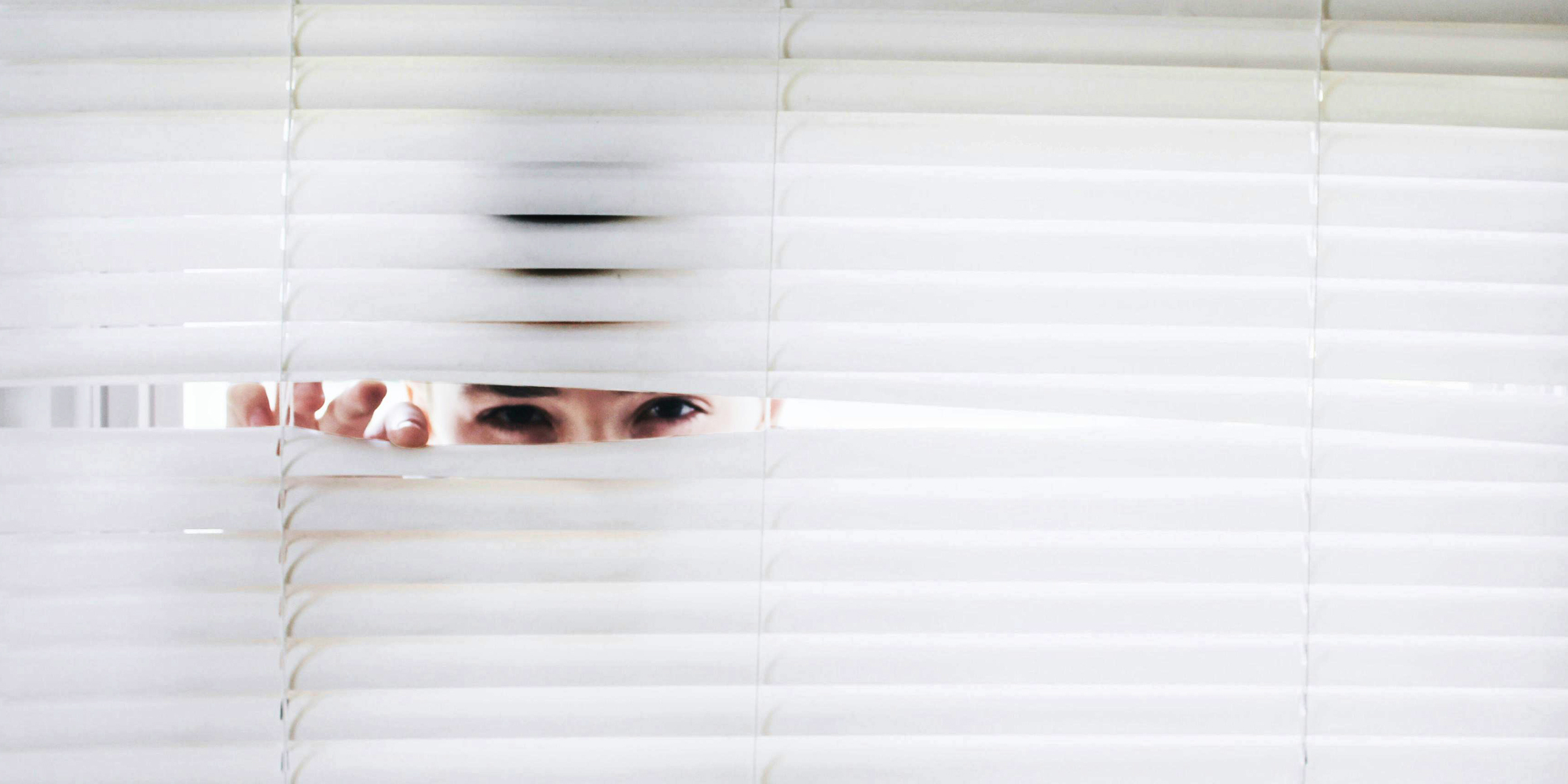 Un hombre espiando a través de las persianas de una ventana | Fuente: Pexels