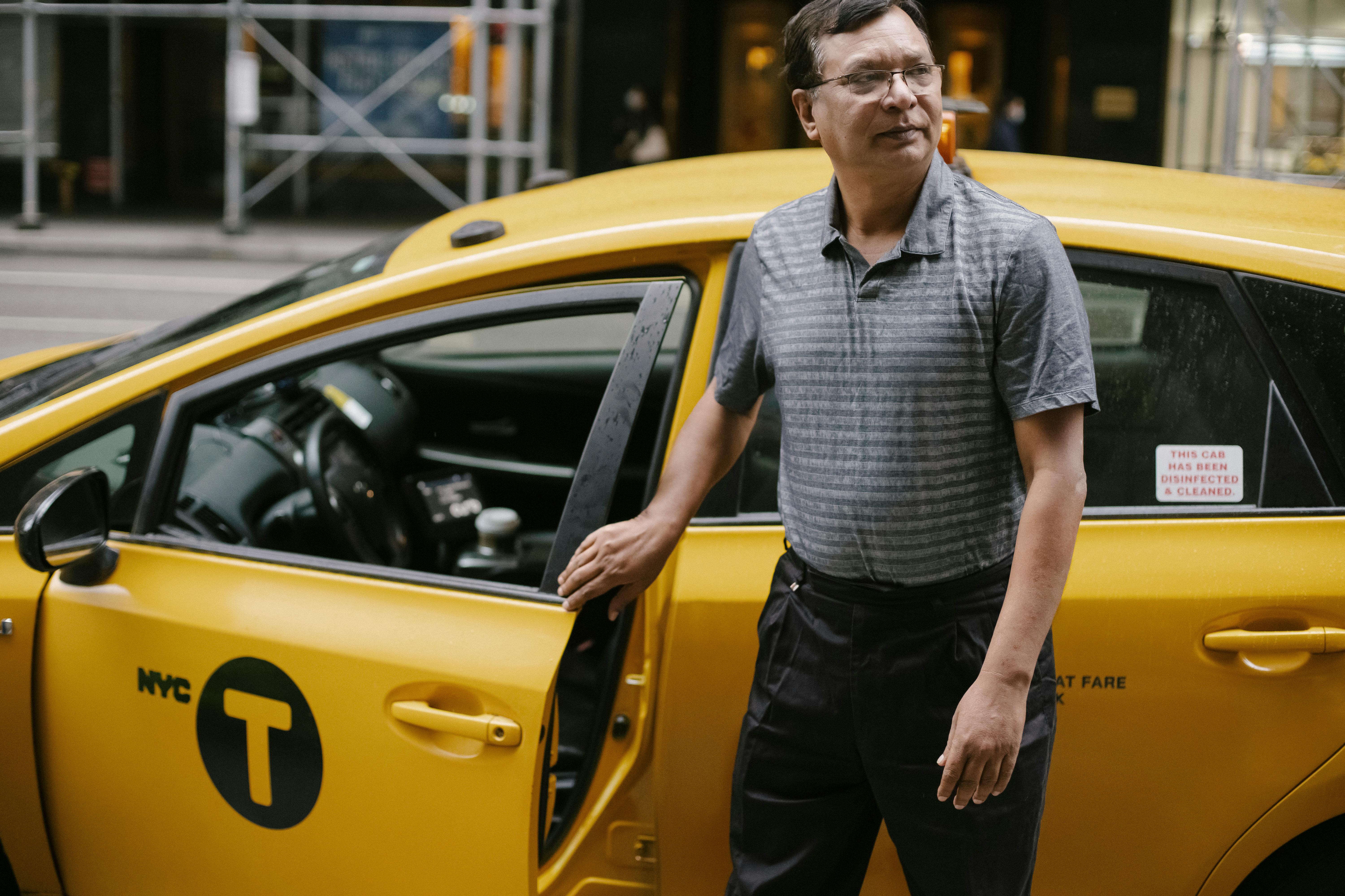 Un taxista junto a su automóvil | Fuente: Pexels