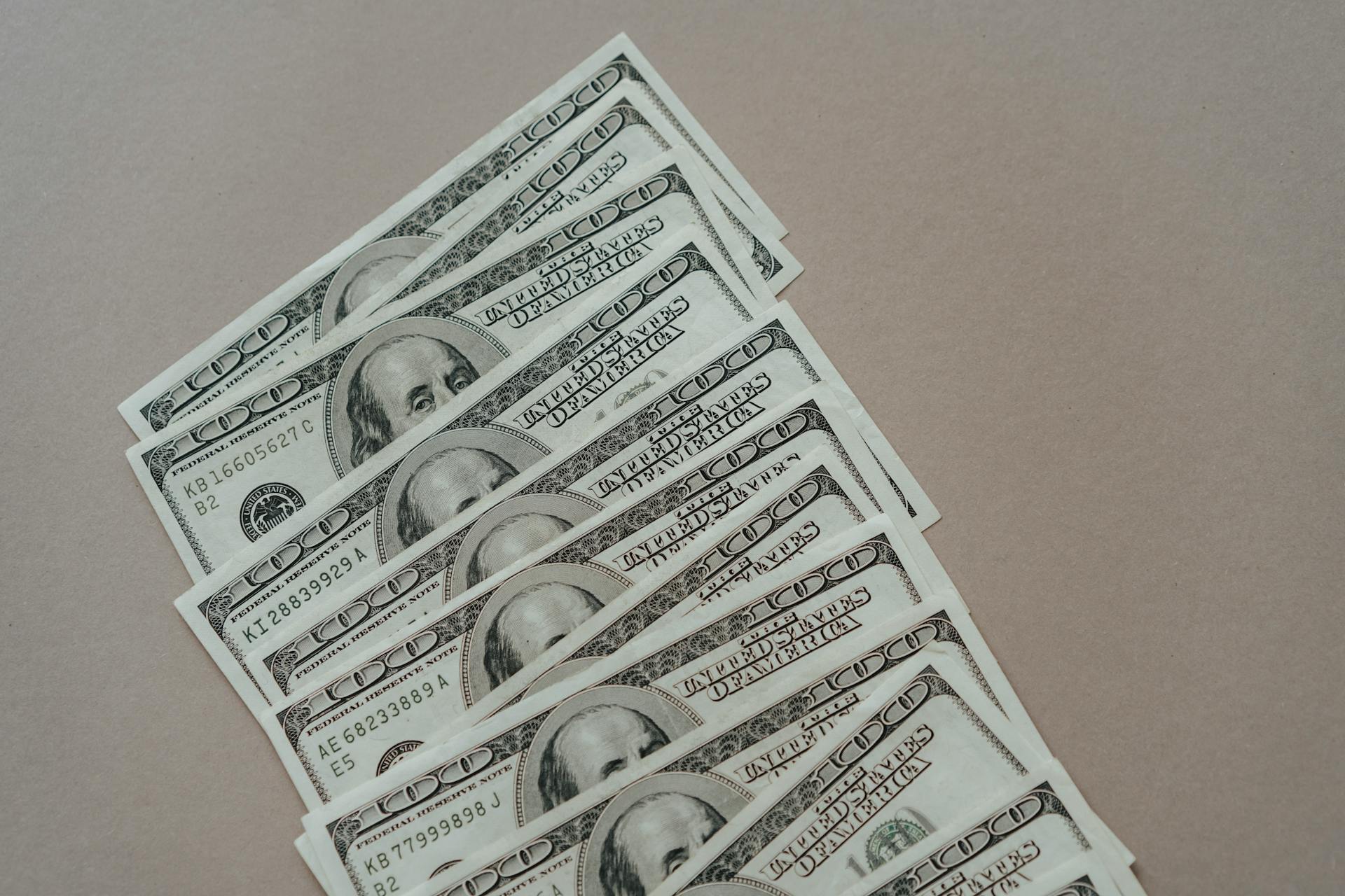 Billetes de dólar sobre una superficie gris | Fuente: Pexels
