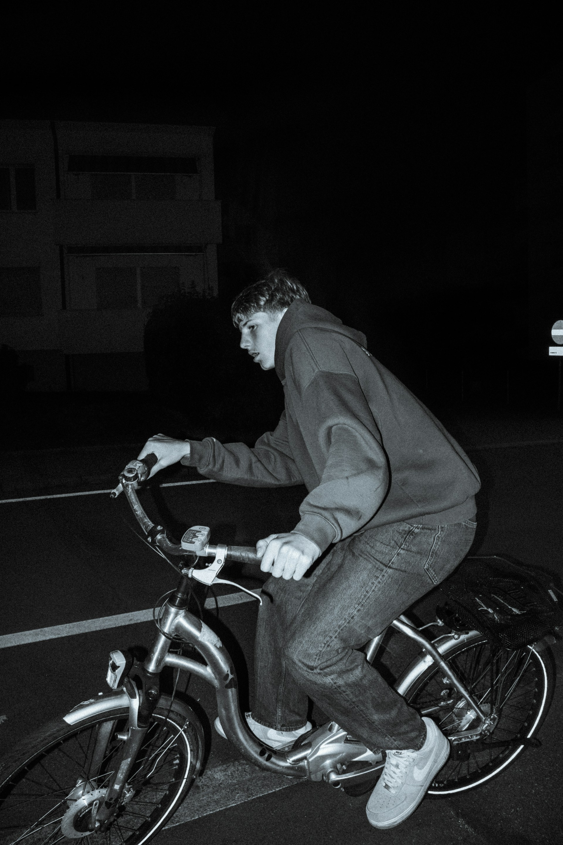 Toma en escala de grises de un joven en bicicleta por la carretera | Fuente: Unsplash