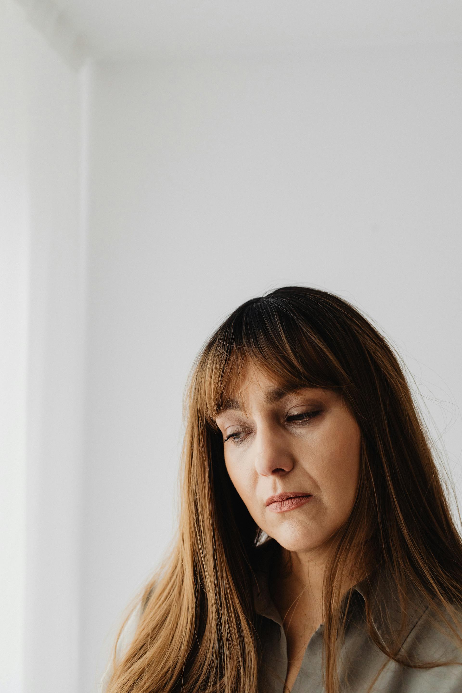 Una mujer mirando hacia abajo | Fuente: Pexels