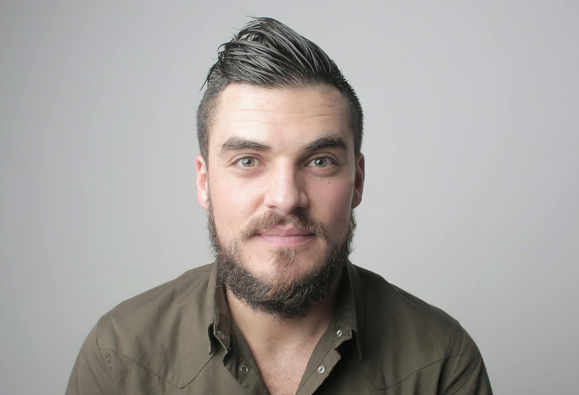 Un hombre sonriendo débilmente | Fuente: Pexels