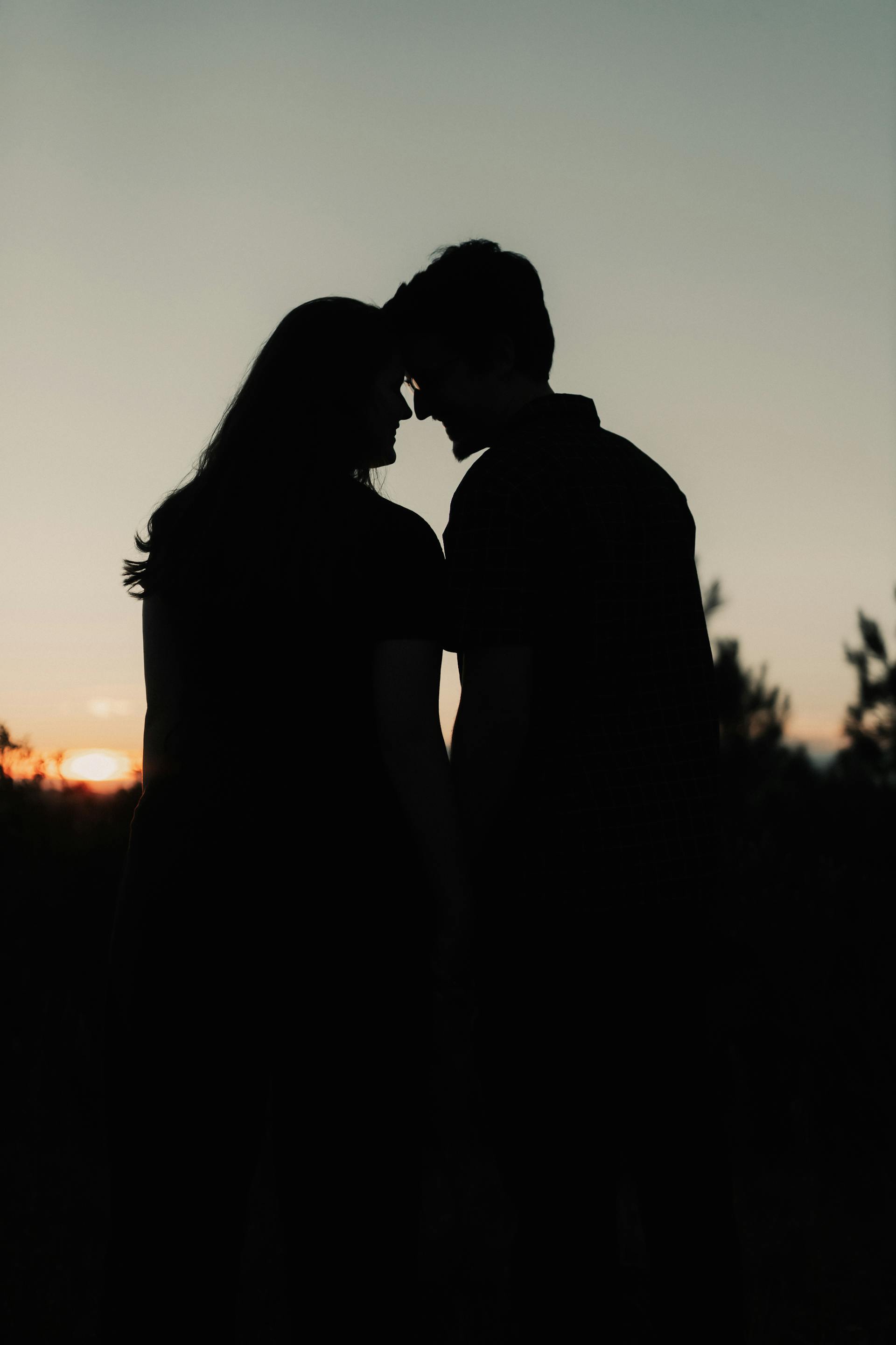 Silueta de una pareja romántica al atardecer | Fuente: Pexels