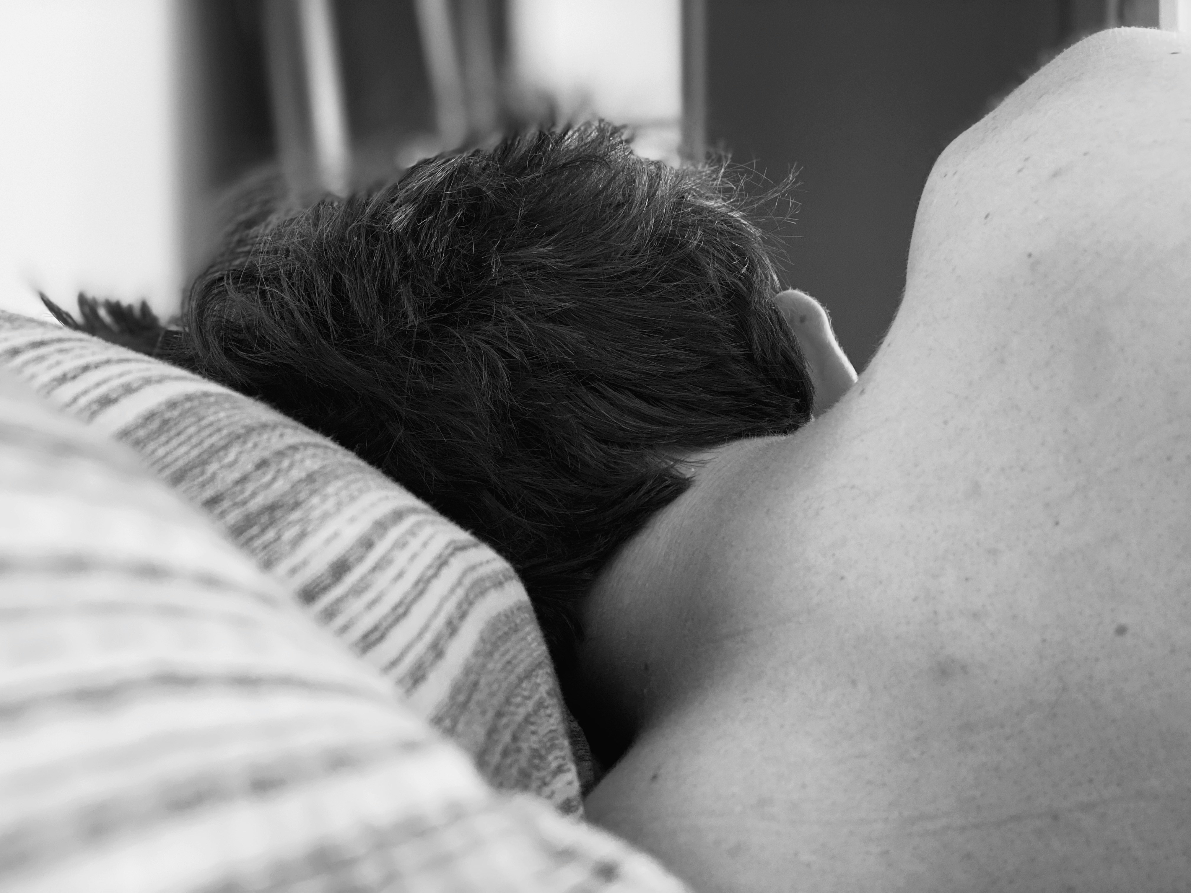 Vista trasera de un hombre durmiendo en su cama | Fuente: Unsplash