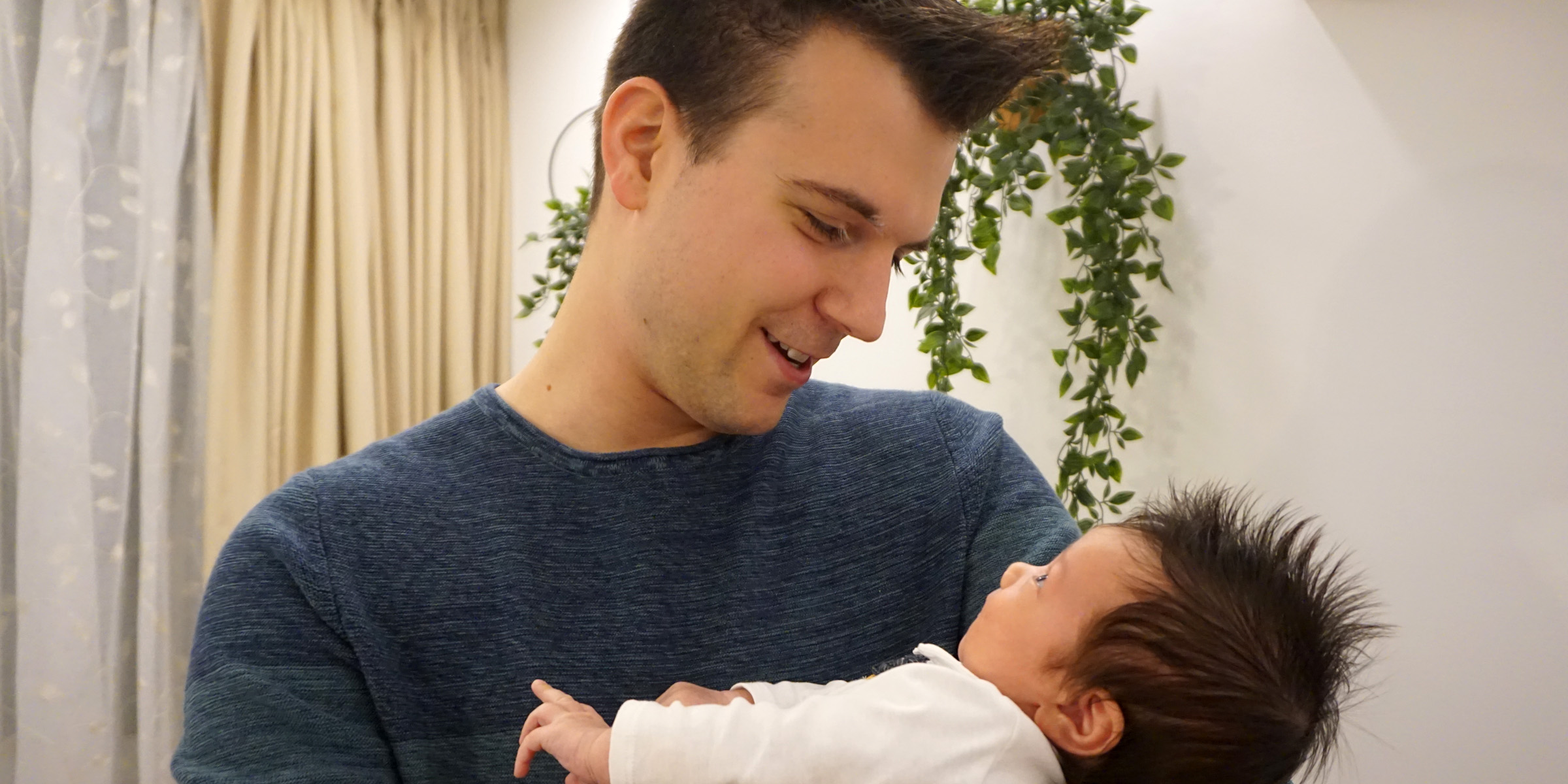Un hombre con un bebé en brazos | Fuente: Shutterstock