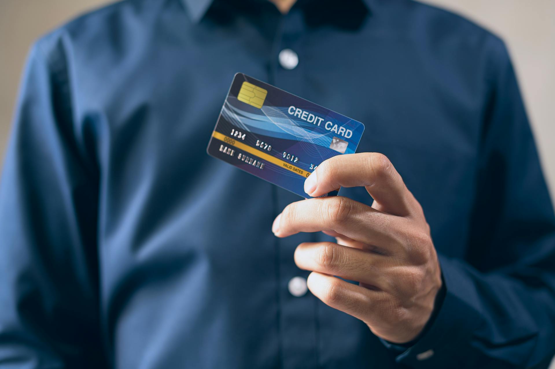 Un hombre sujetando su tarjeta de crédito | Fuente: Pexels