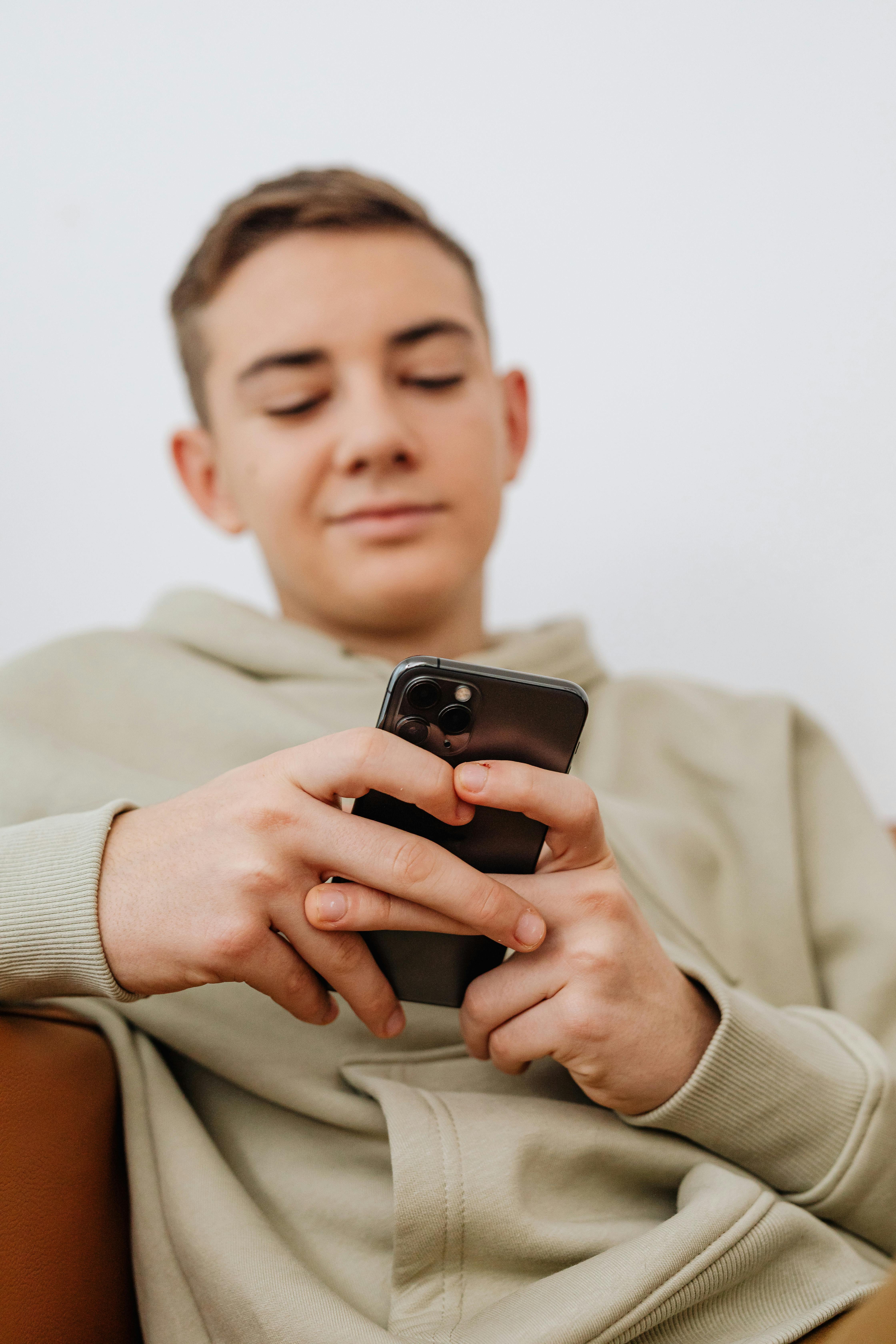 Un adolescente usando su teléfono | Fuente: Pexels