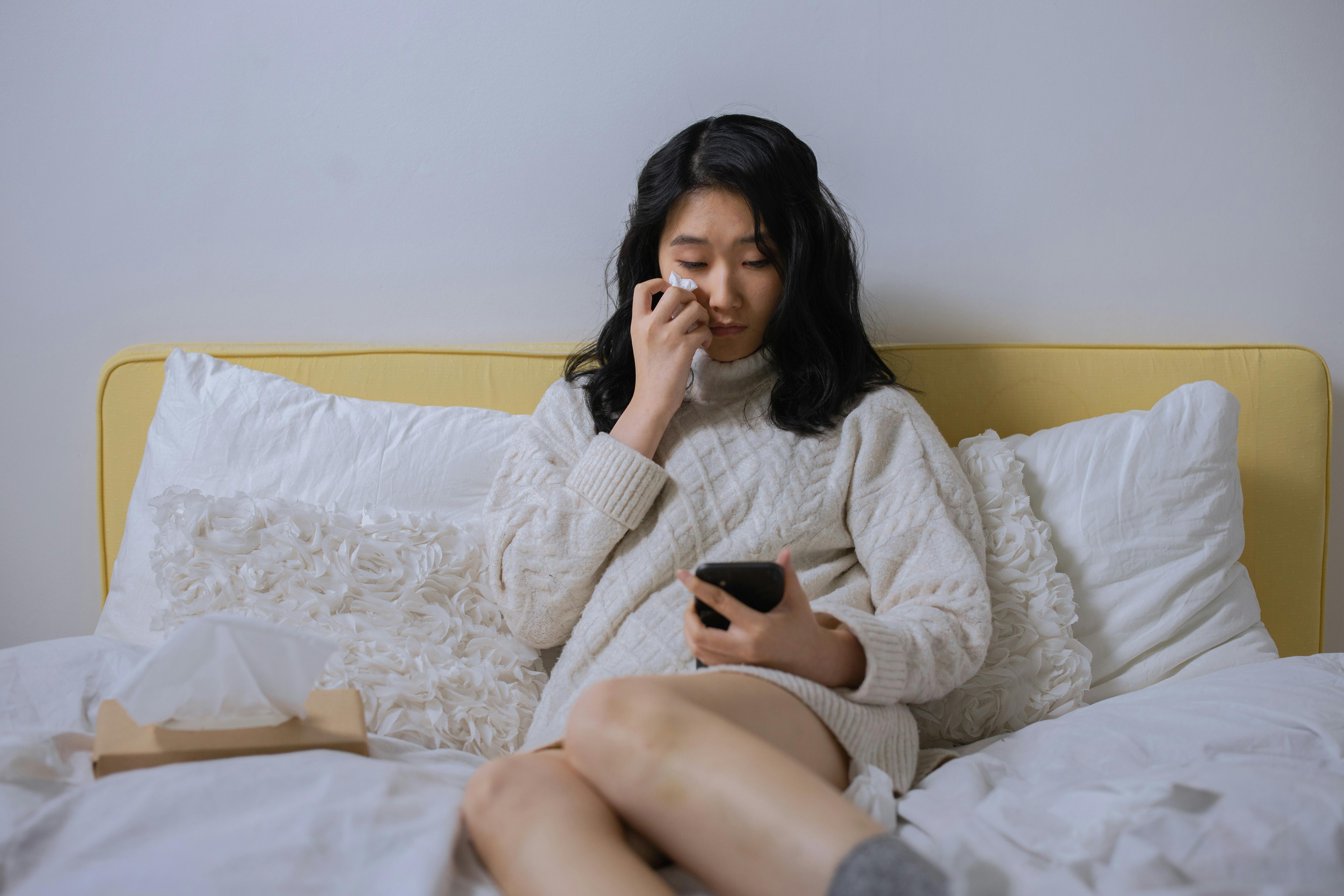 Una mujer llora mientras mira su móvil | Fuente: Pexels