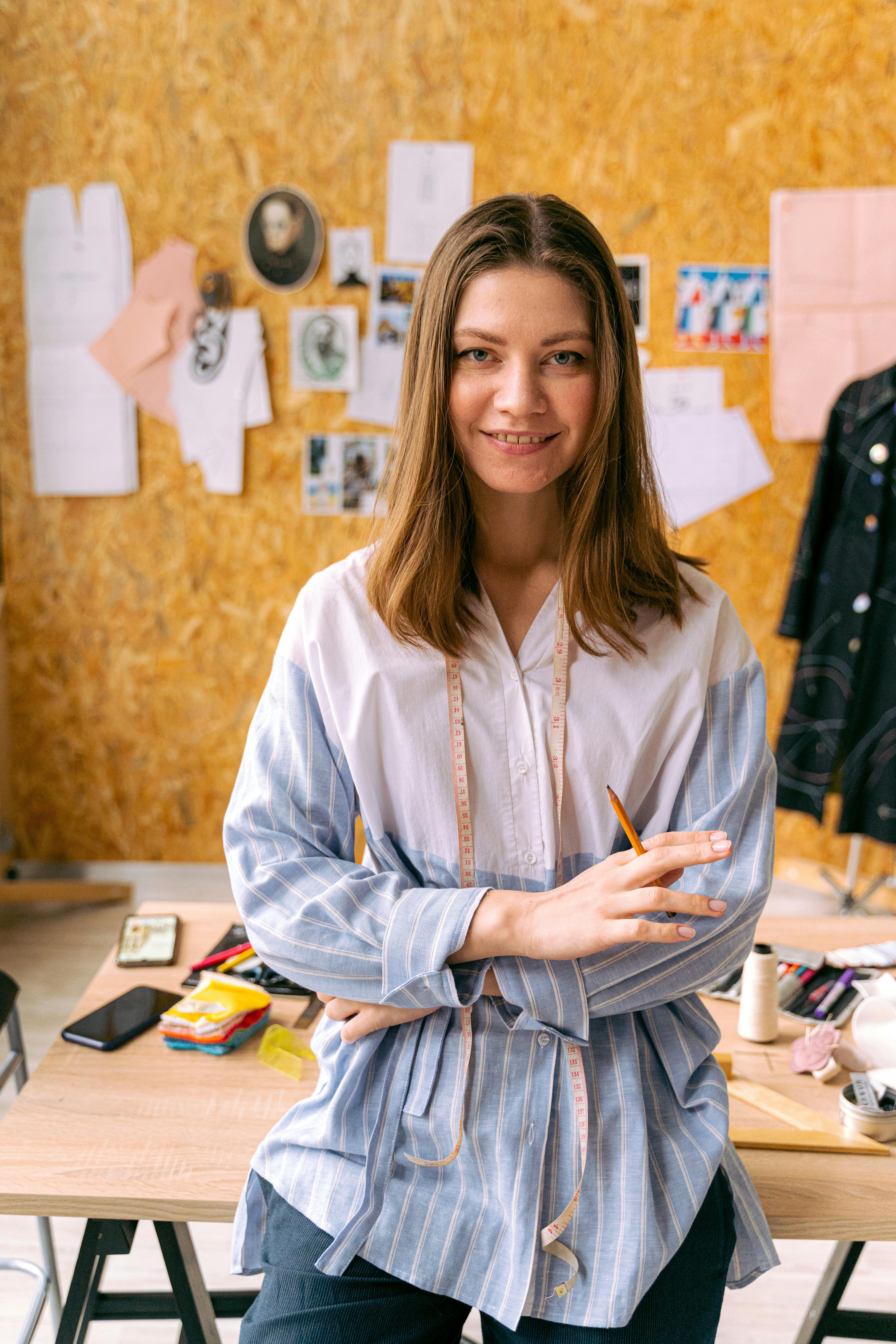 Una mujer sonriendo mientras se prepara para coser | Fuente: Pexels