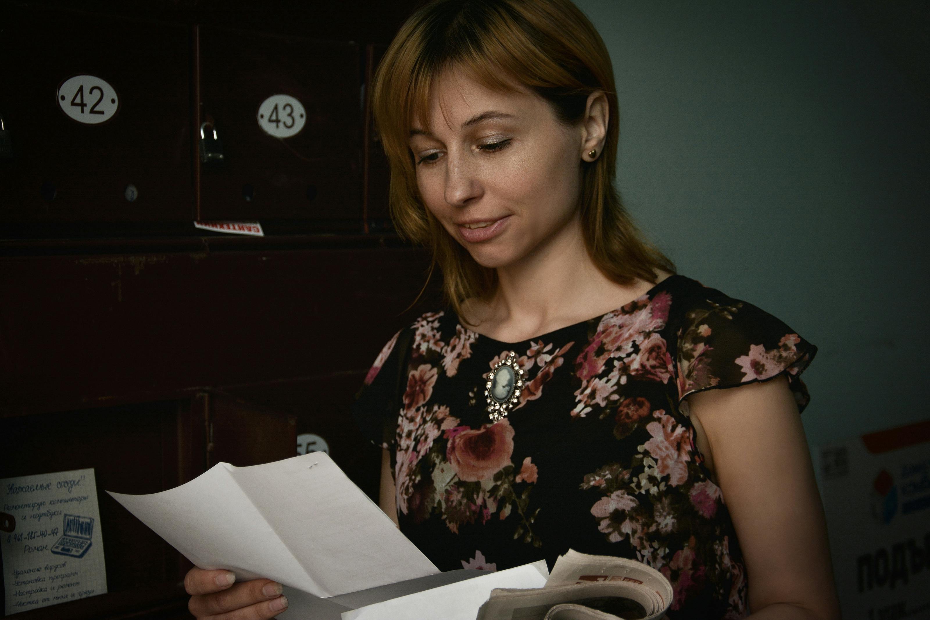 Una mujer de pie leyendo una carta | Fuente: Pexels