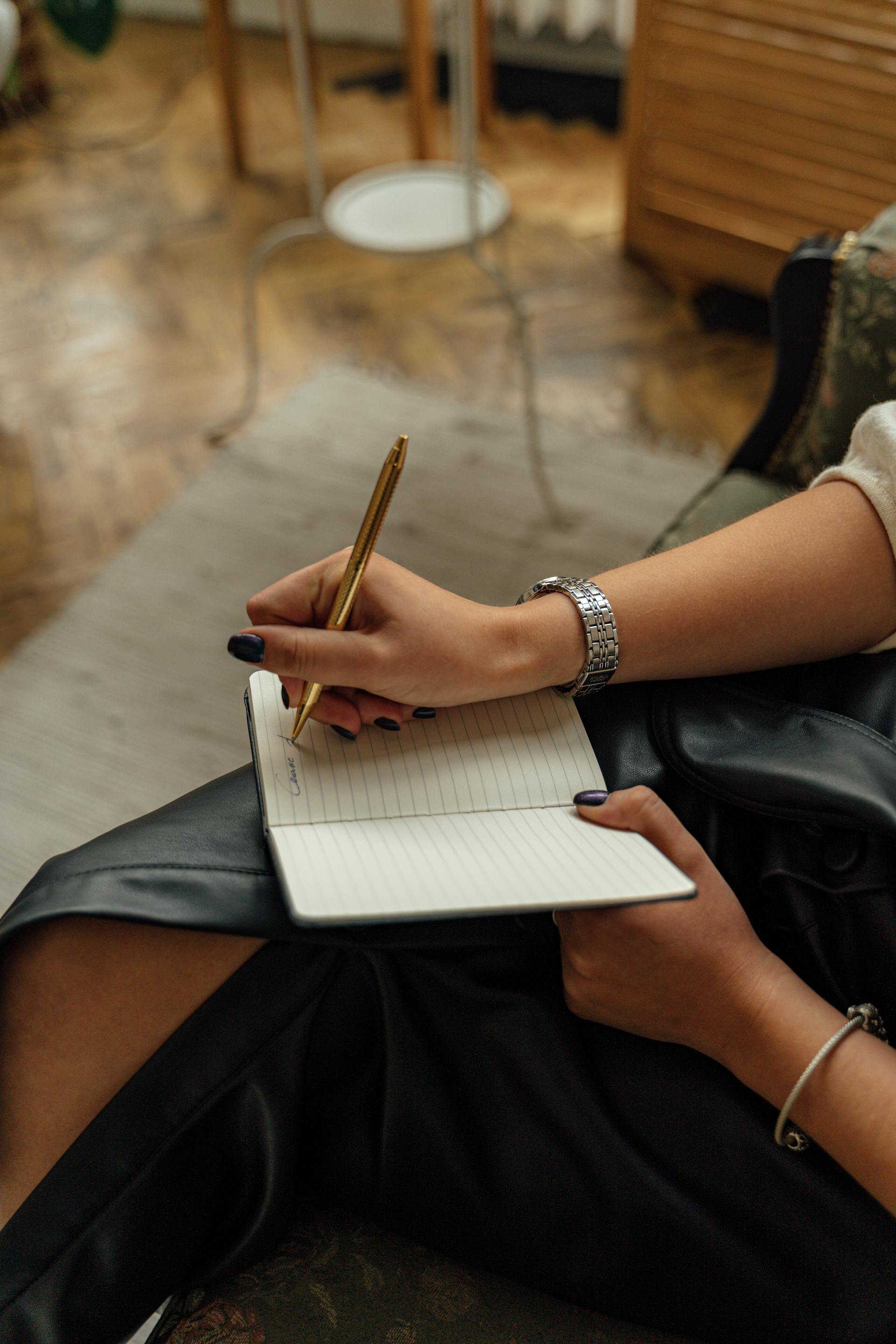Primer plano de una mujer escribiendo en un cuaderno | Fuente: Pexels