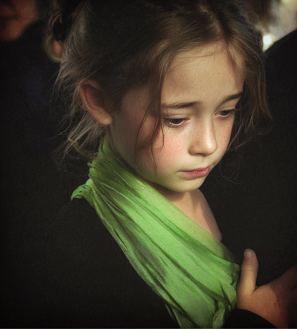 Una niña con un pañuelo verde en la mano | Fuente: Midjourney