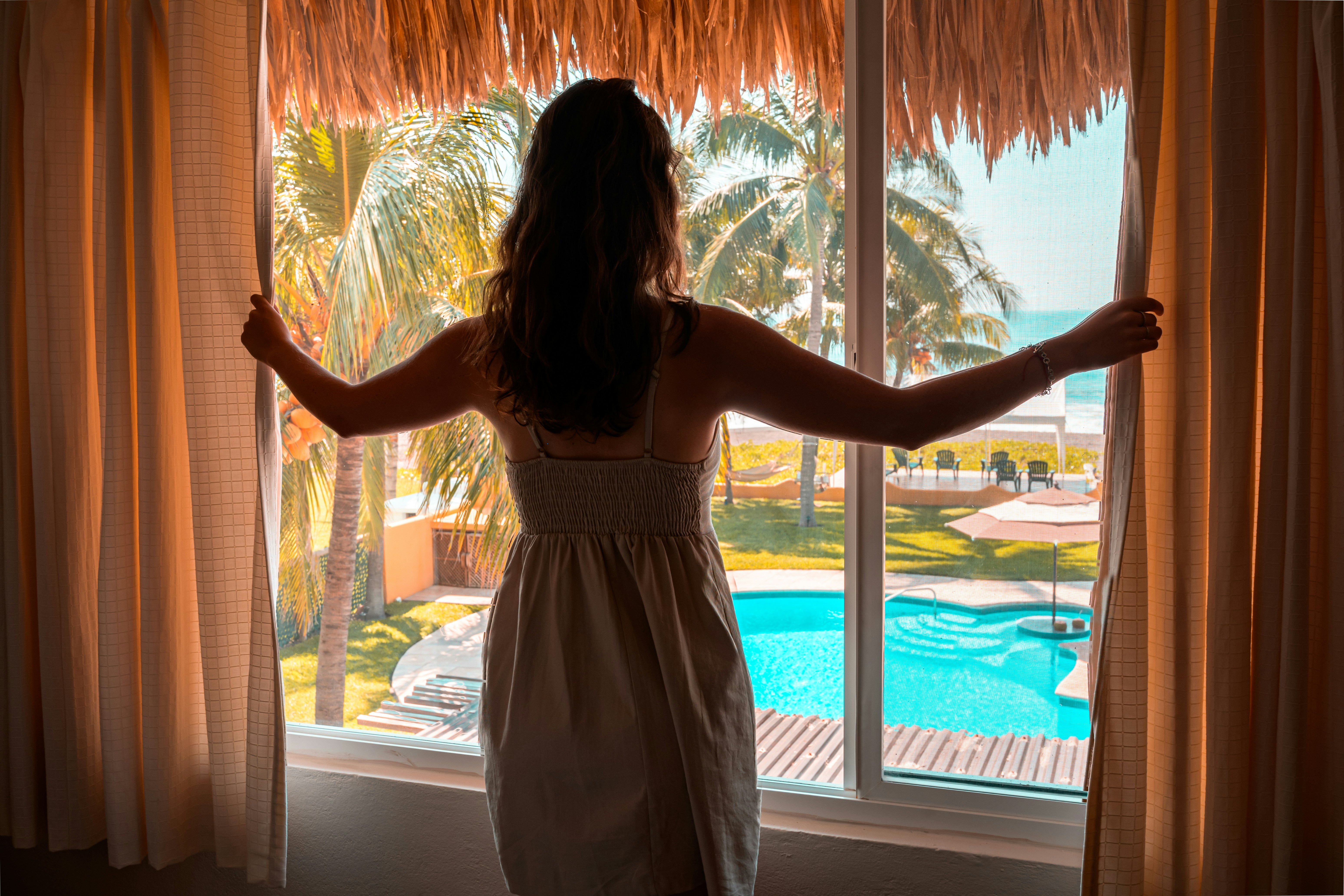 Una persona junto a la ventana de una habitación de hotel | Fuente: Unsplash