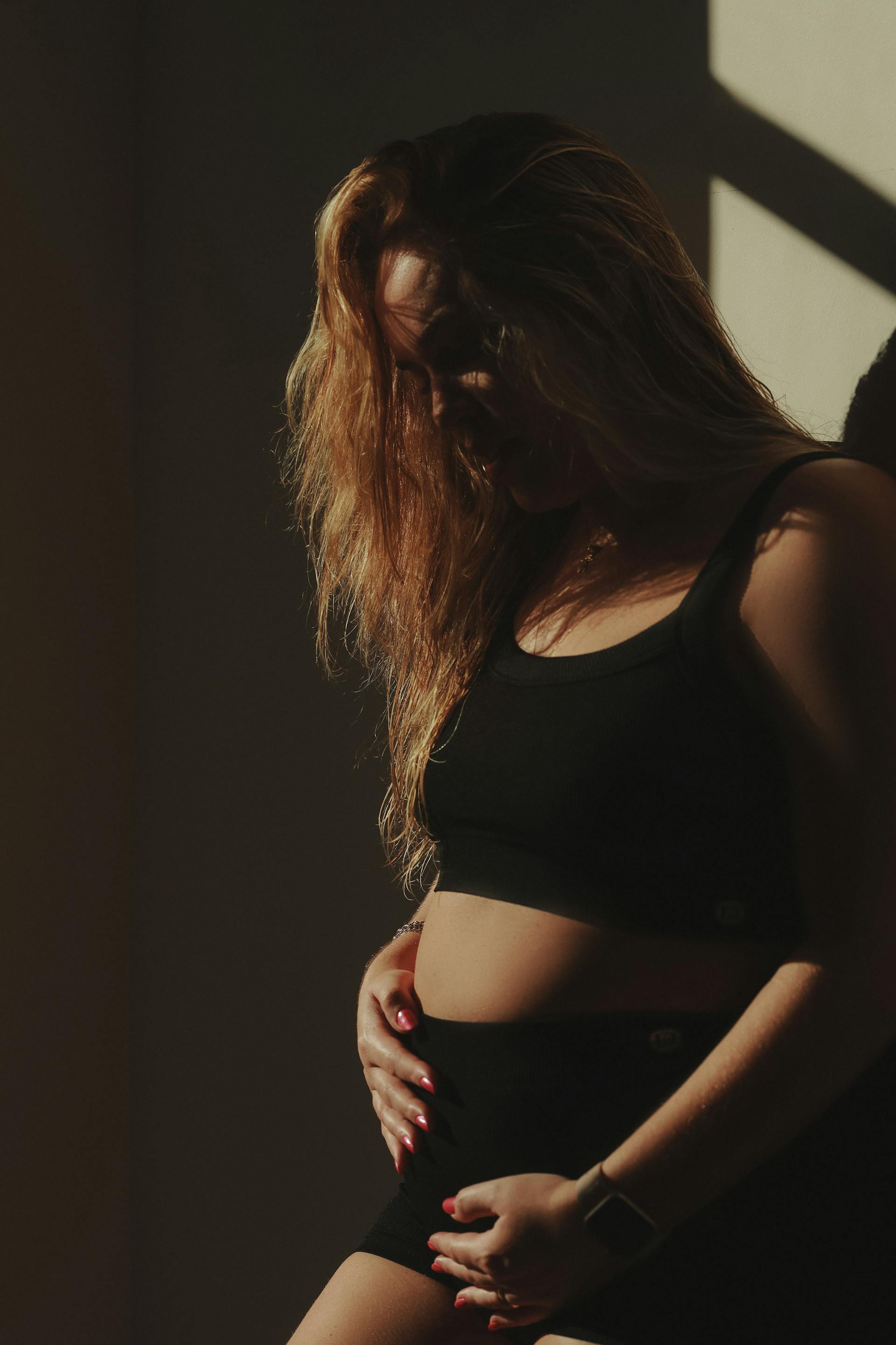 Una mujer embarazada tocándose el vientre | Fuente: Pexels