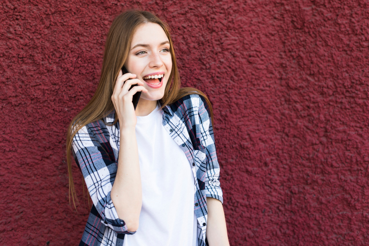 Una mujer riendo mientras habla por teléfono | Fuente: Freepik