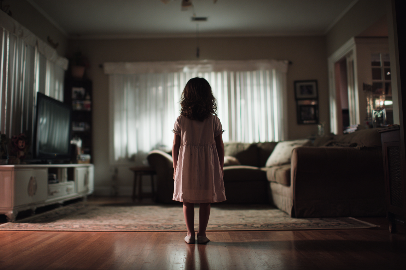 Una niña de pie en un salón | Fuente: Midjourney