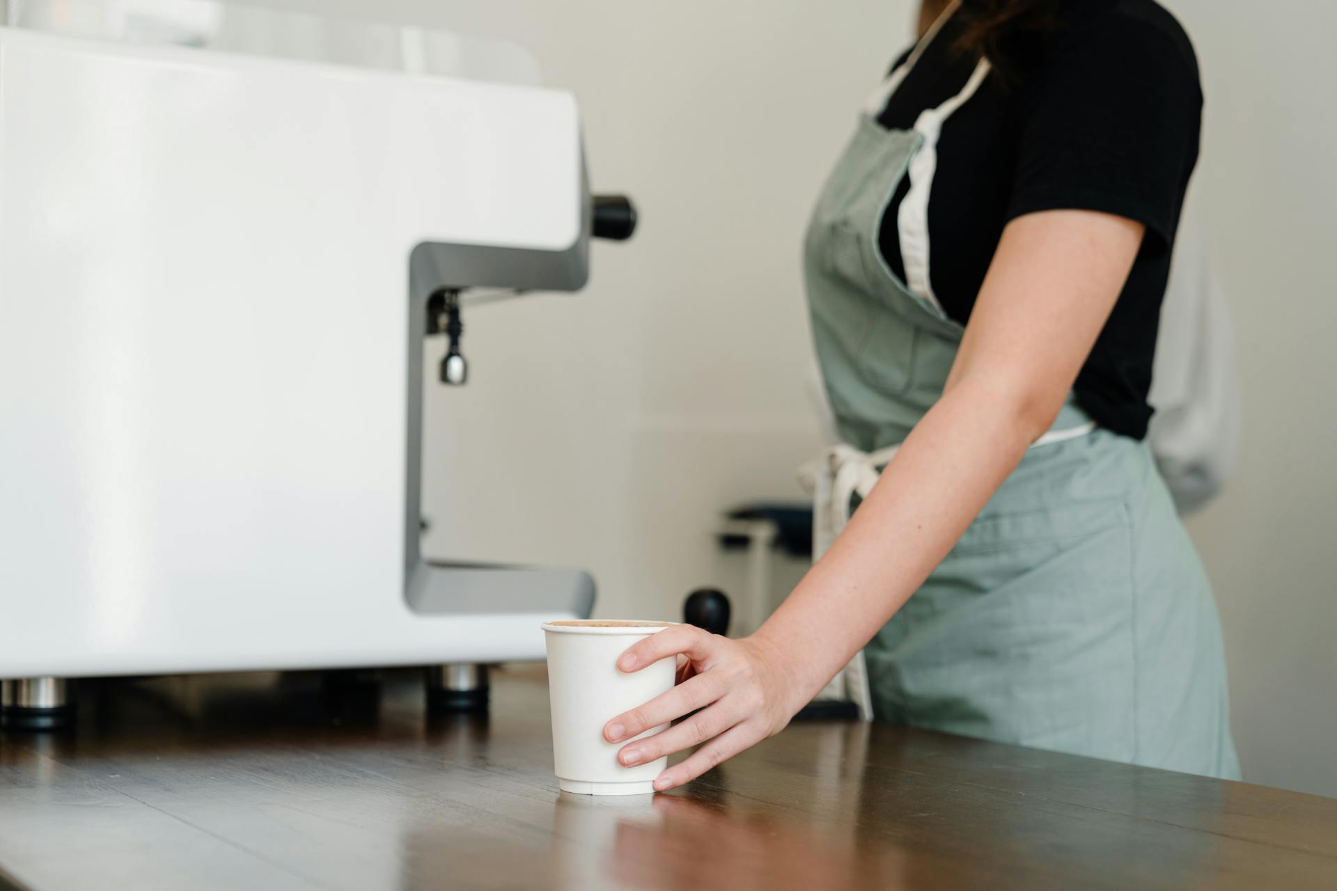 Una camarera cerca de una máquina de café | Fuente: Pexels