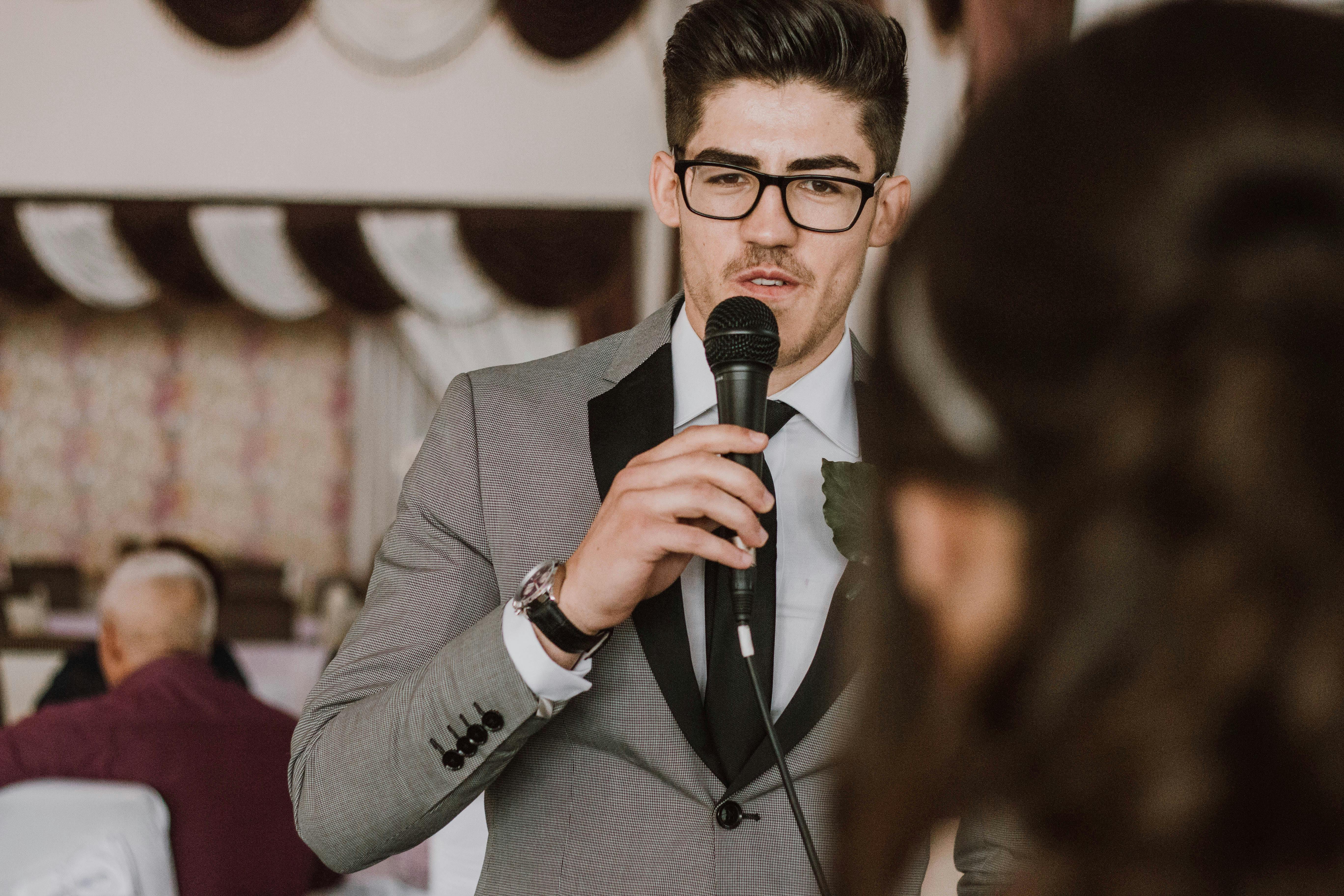 Un hombre serio hablando por un micro | Fuente: Pexels