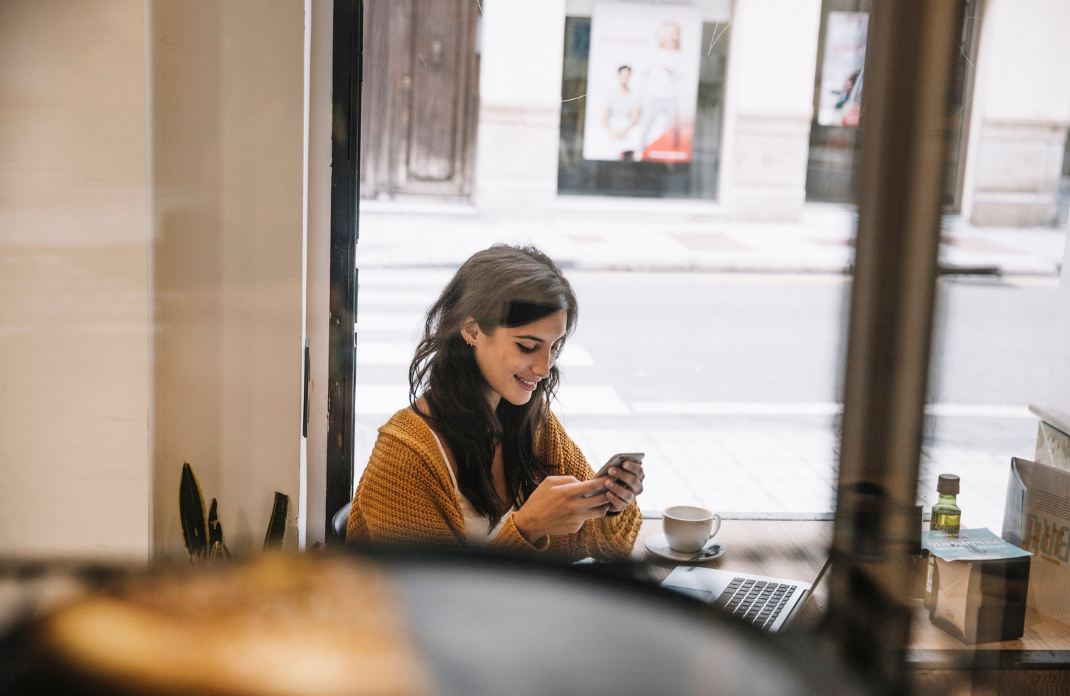 Una mujer mirando su teléfono y sonriendo | Fuente: Freepik
