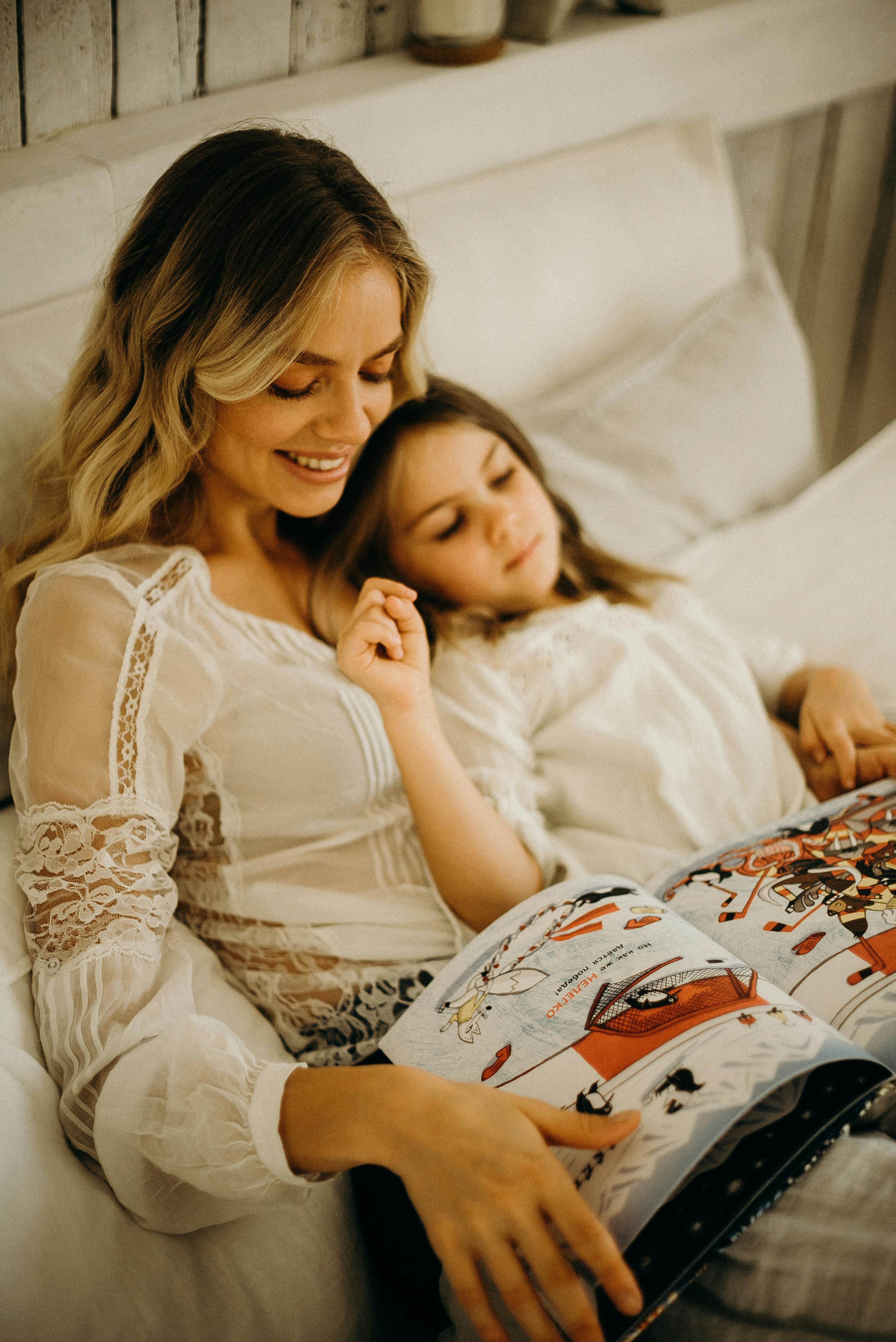 Una madre y su hija tumbadas en la cama | Fuente: Pexels