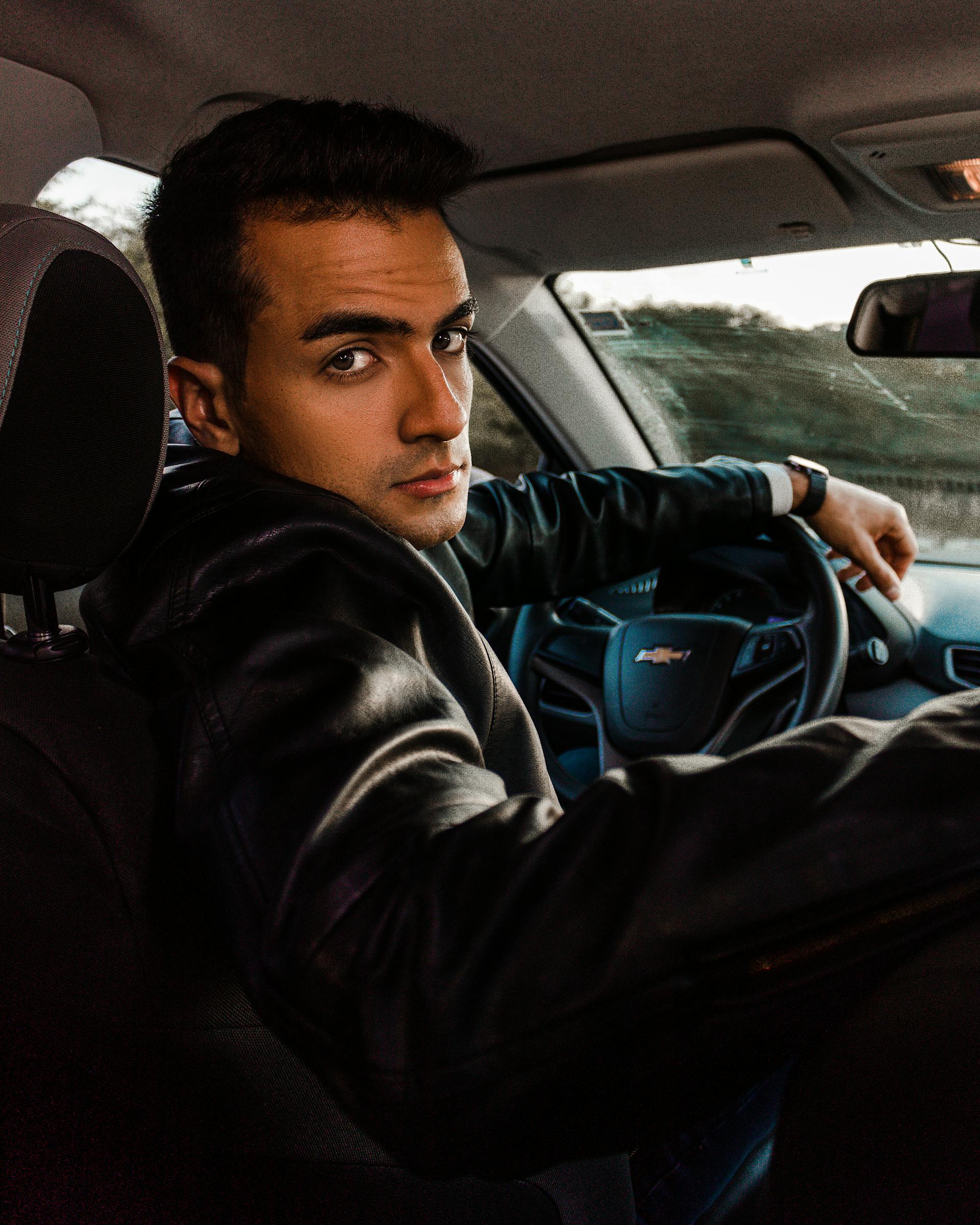 Un hombre mirando hacia atrás en su automóvil | Fuente: Pexels