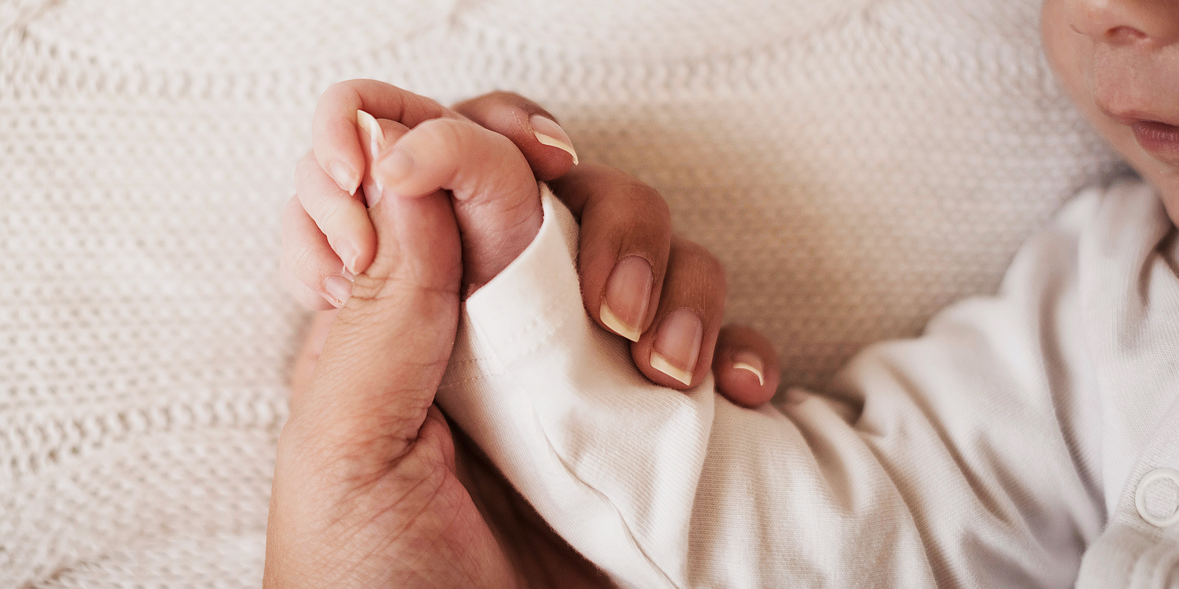 Una mujer sujetando la mano a un bebé | Fuente: Freepik