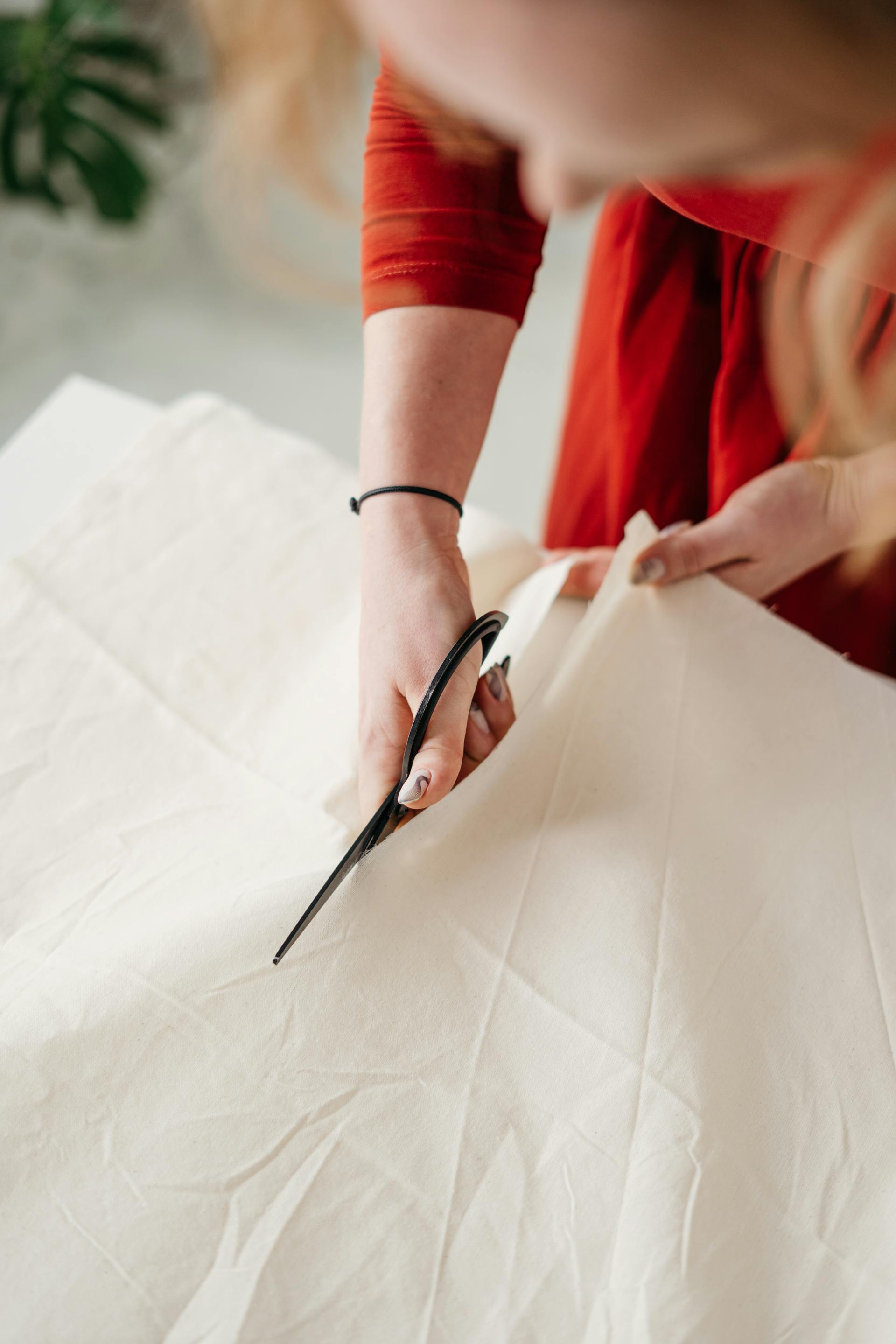 Una mujer cortando un vestido | Fuente: Pexels