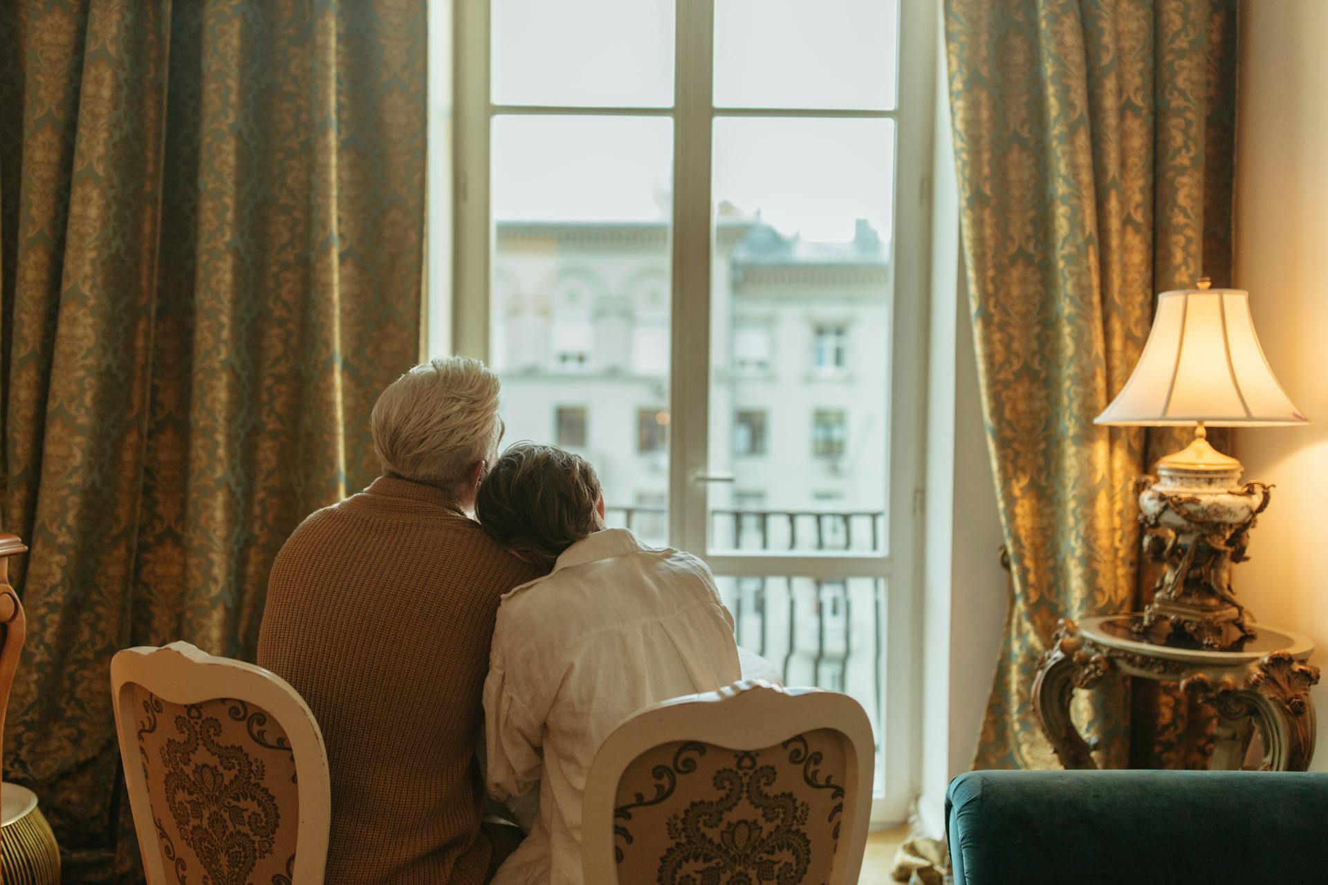 Una pareja de ancianos mirando por la ventana | Fuente: Pexels