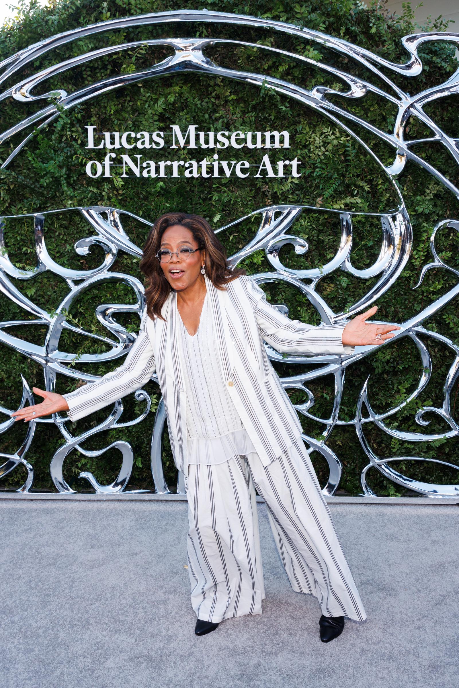 Winfrey cambió de pose para otra foto, abriendo los brazos de par en par con el Museo Lucas de fondo. Ese momento tan divertido mostró otra faceta de su aparición en la noche de inauguración. | Fuente: Getty Images
