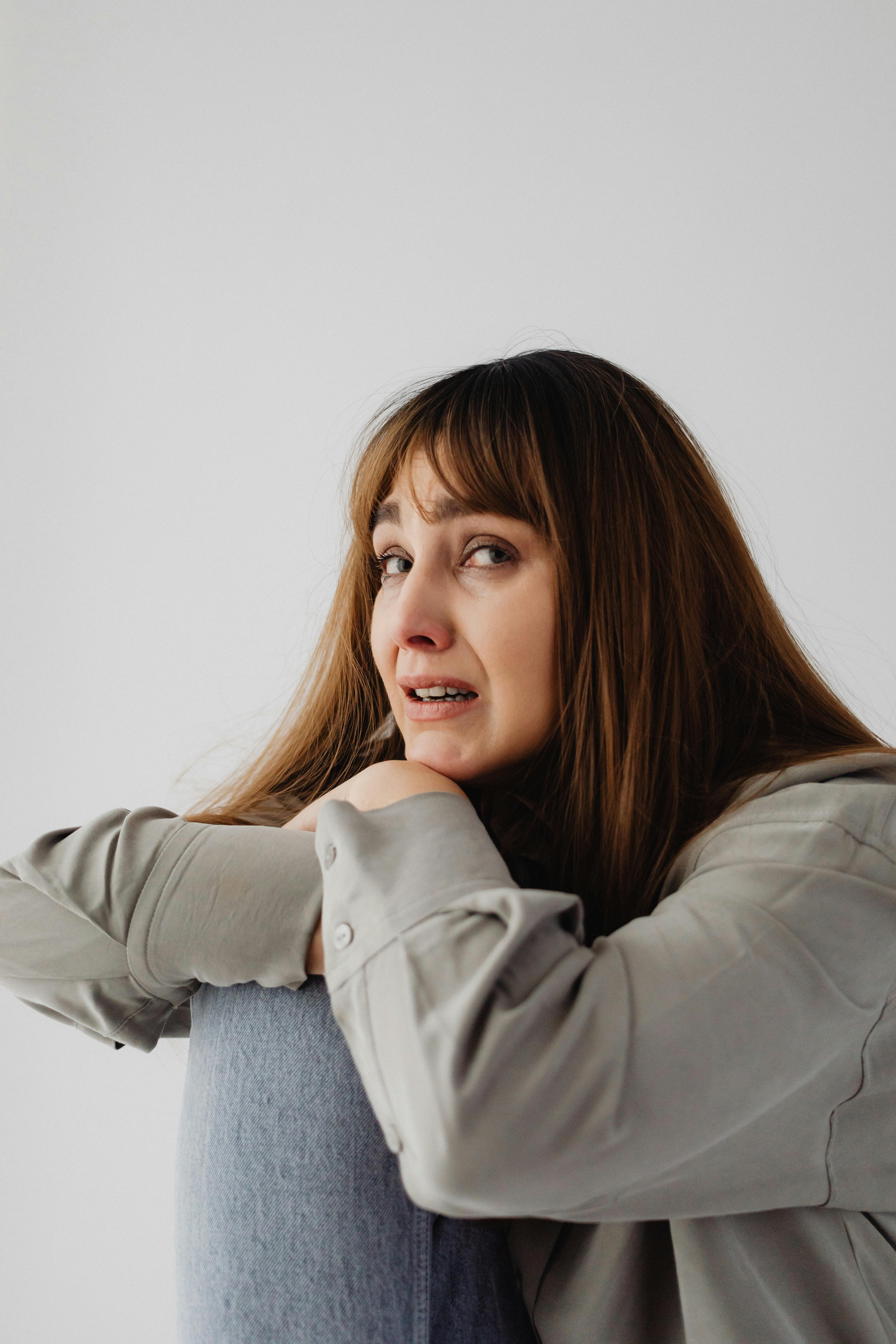 Una mujer emocionada apoyada en una silla | Fuente: Pexels