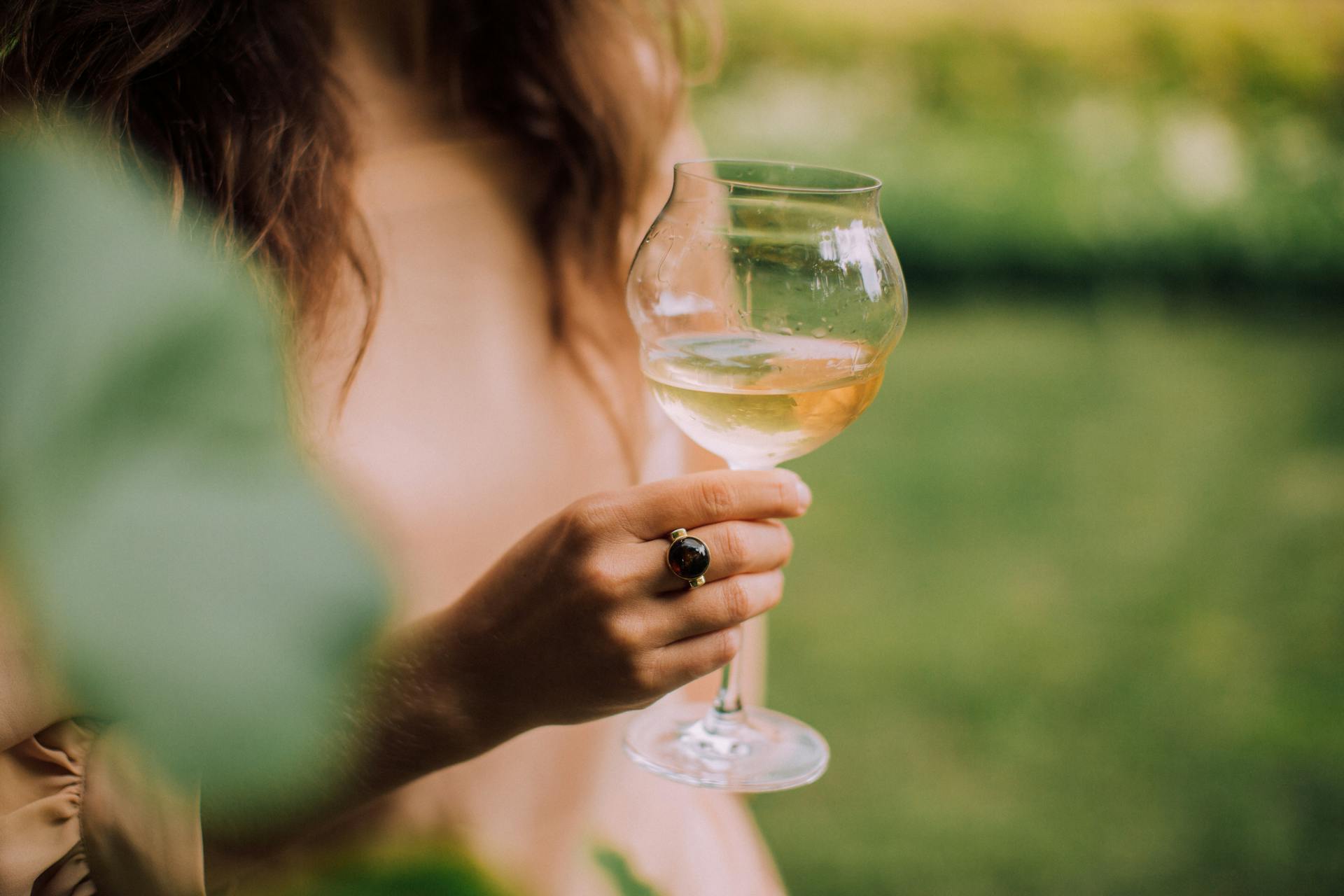 Una mujer con una copa de vino en la mano | Fuente: Pexels