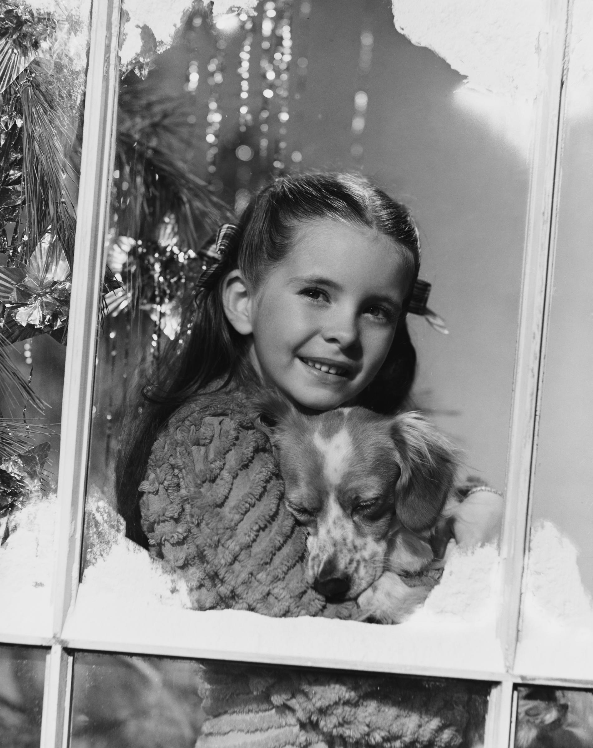 La estrella infantil sosteniendo un cachorro que le regalaron por Navidad en 1942. | Fuente: Getty Images