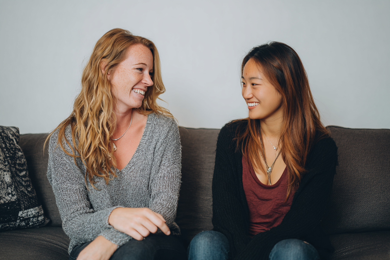 Dos mujeres sonriéndose | Fuente: Midjourney
