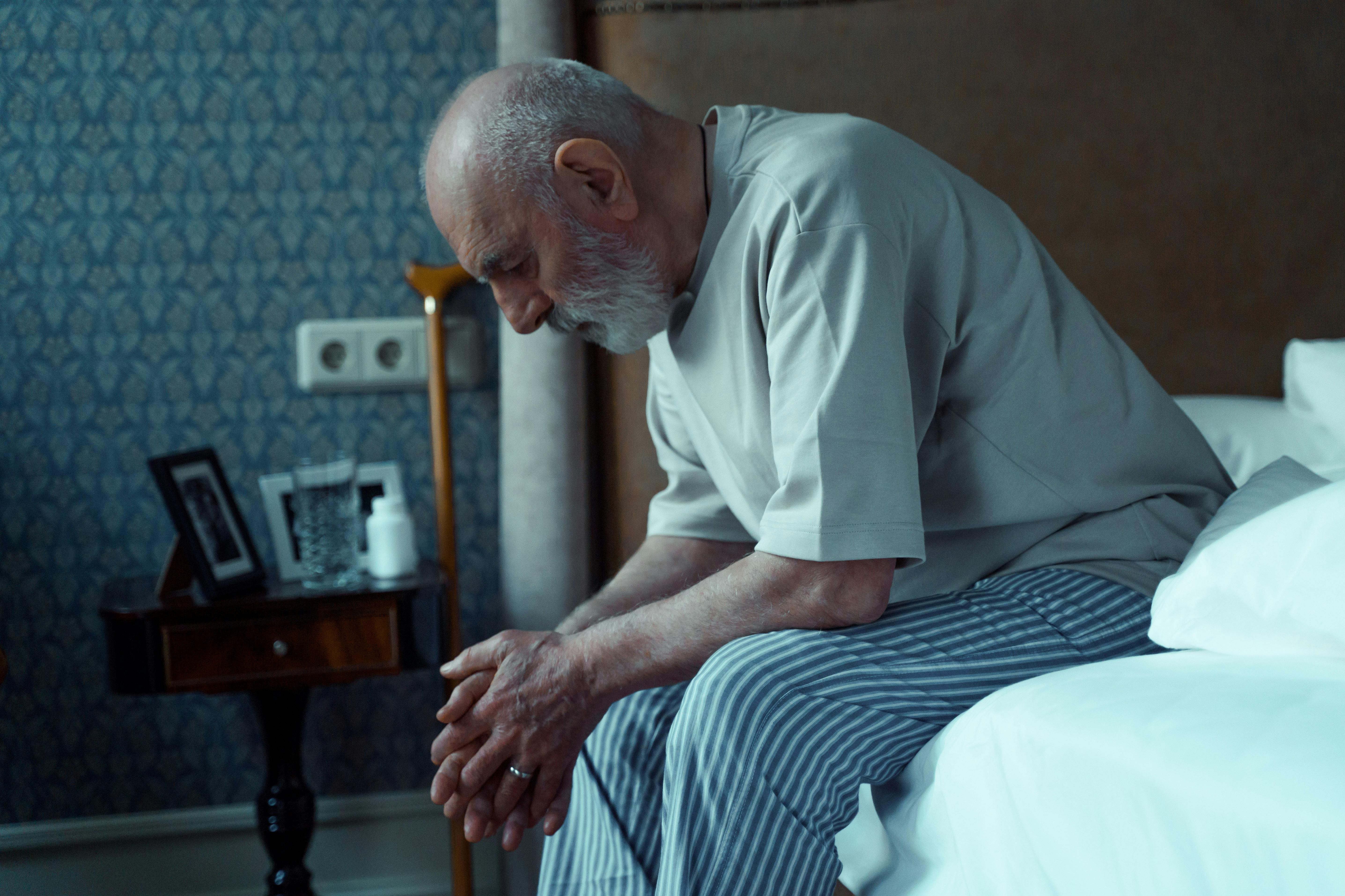 Anciano sentado en la cama | Fuente: Pexels