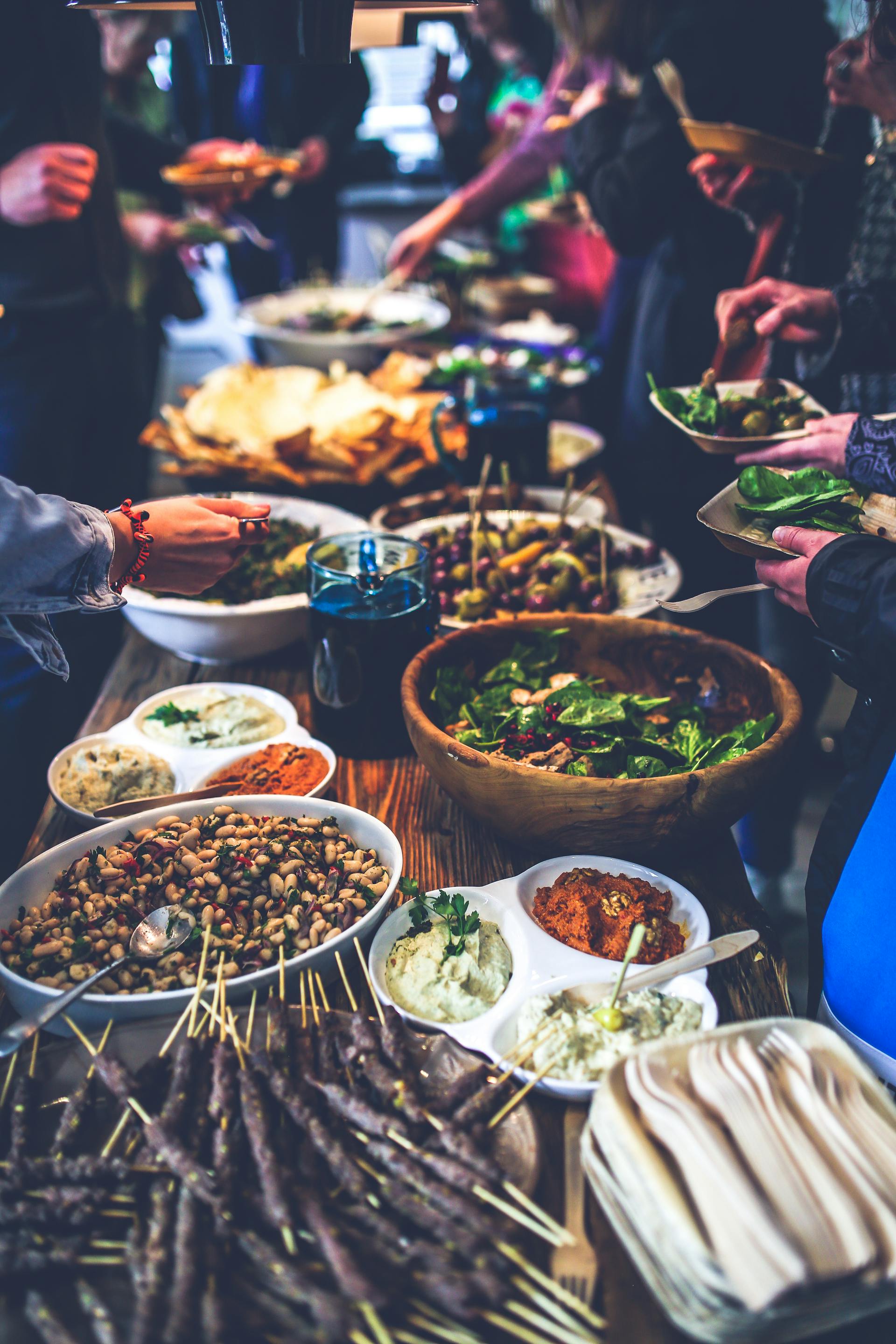 Gente sirviendo comida de un buffet | Fuente: Pexels