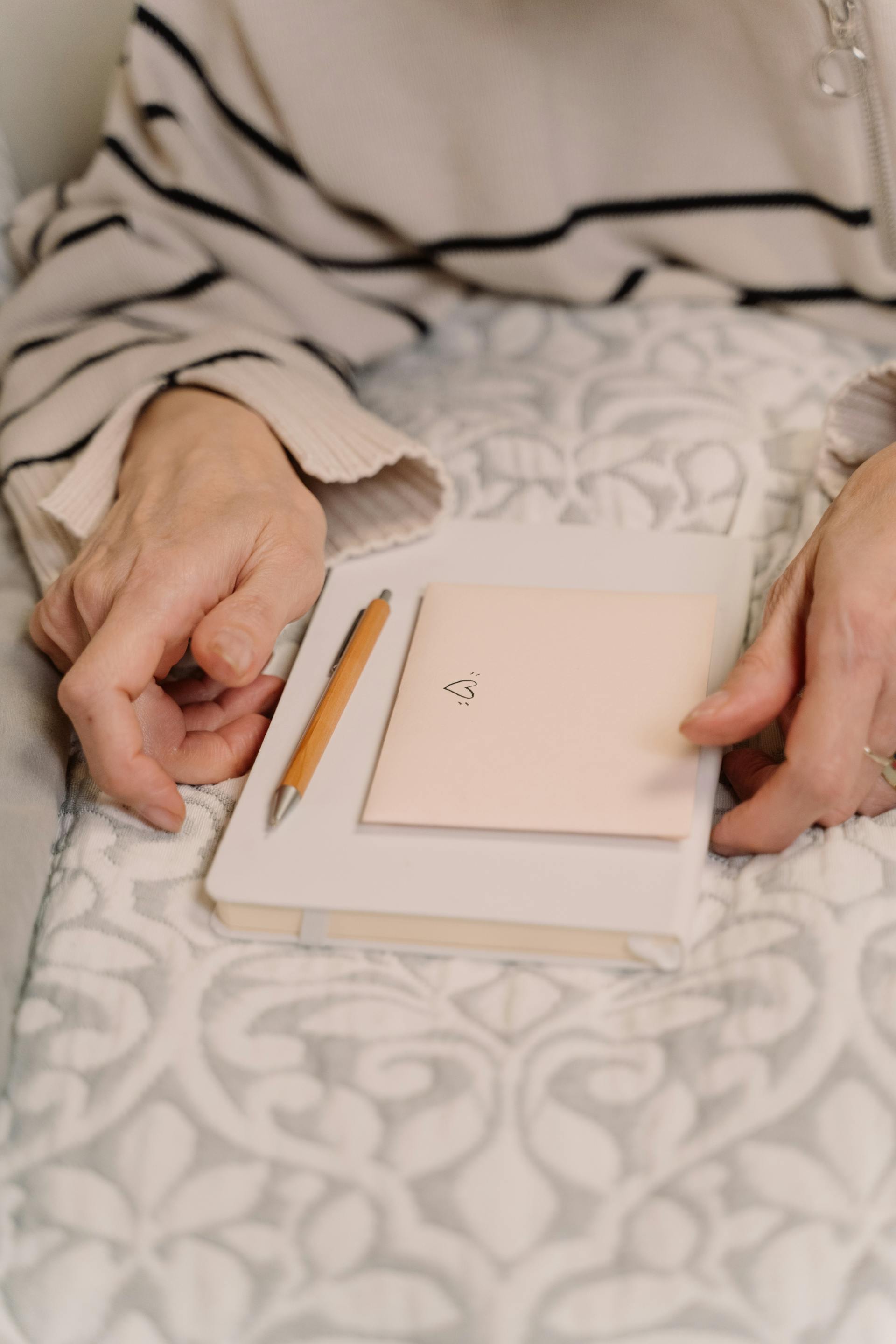 Primer plano de una mujer que sostiene un diario y un sobre | Fuente: Pexels