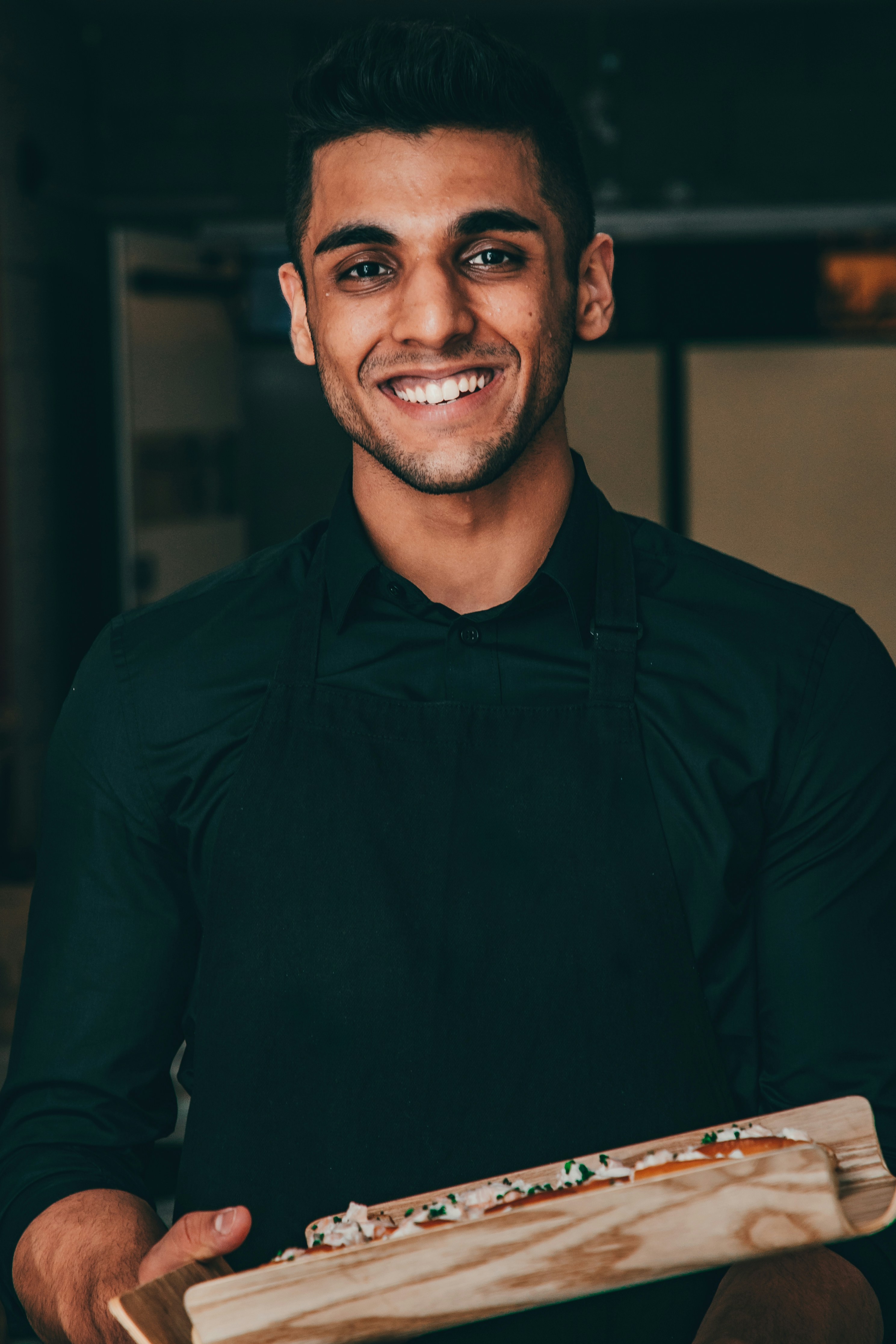 Un camarero joven y sonriente | Fuente: Unsplash
