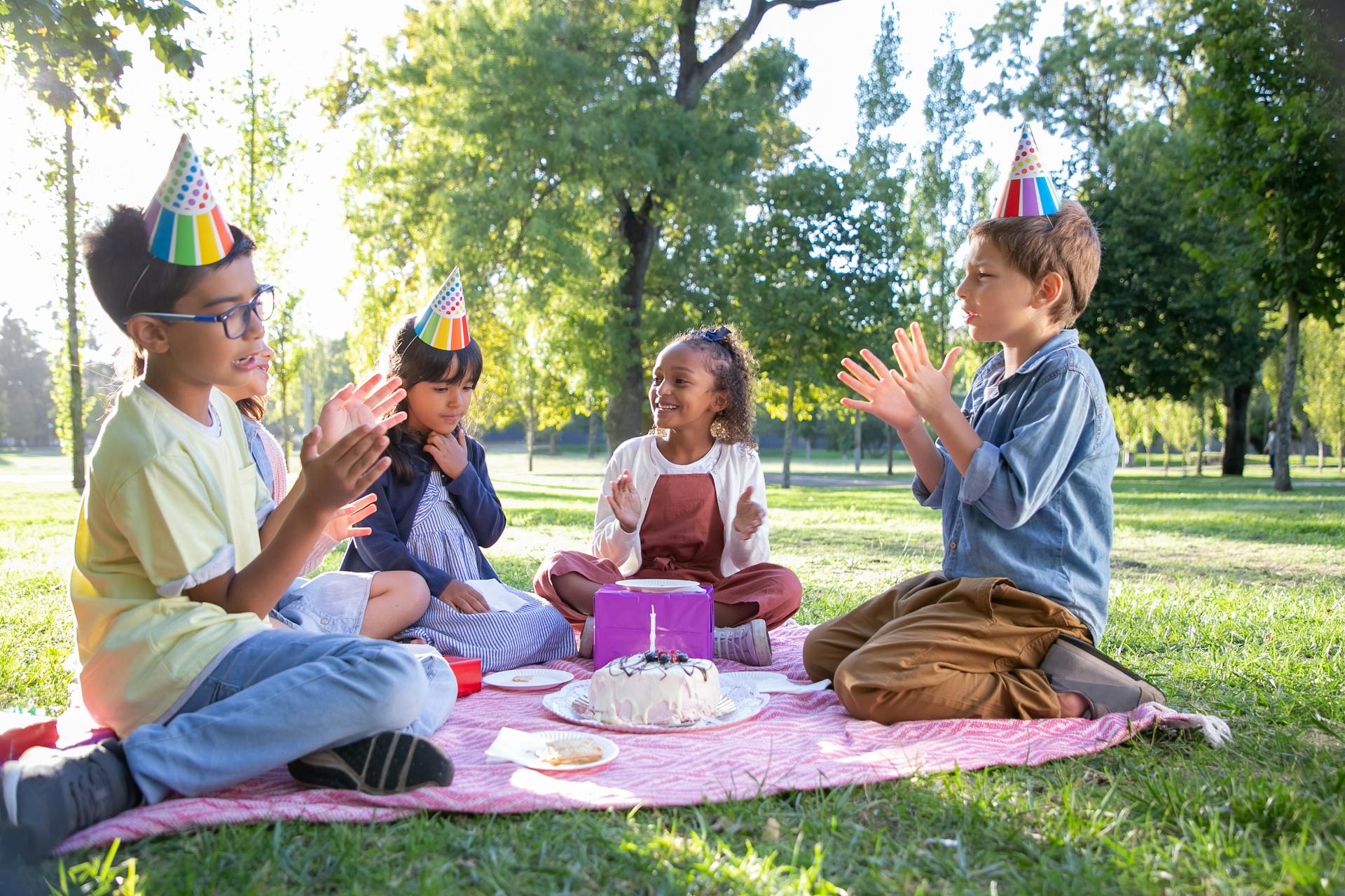 Niños con sombreros de fiesta y aplaudiendo | Fuente: Pexels