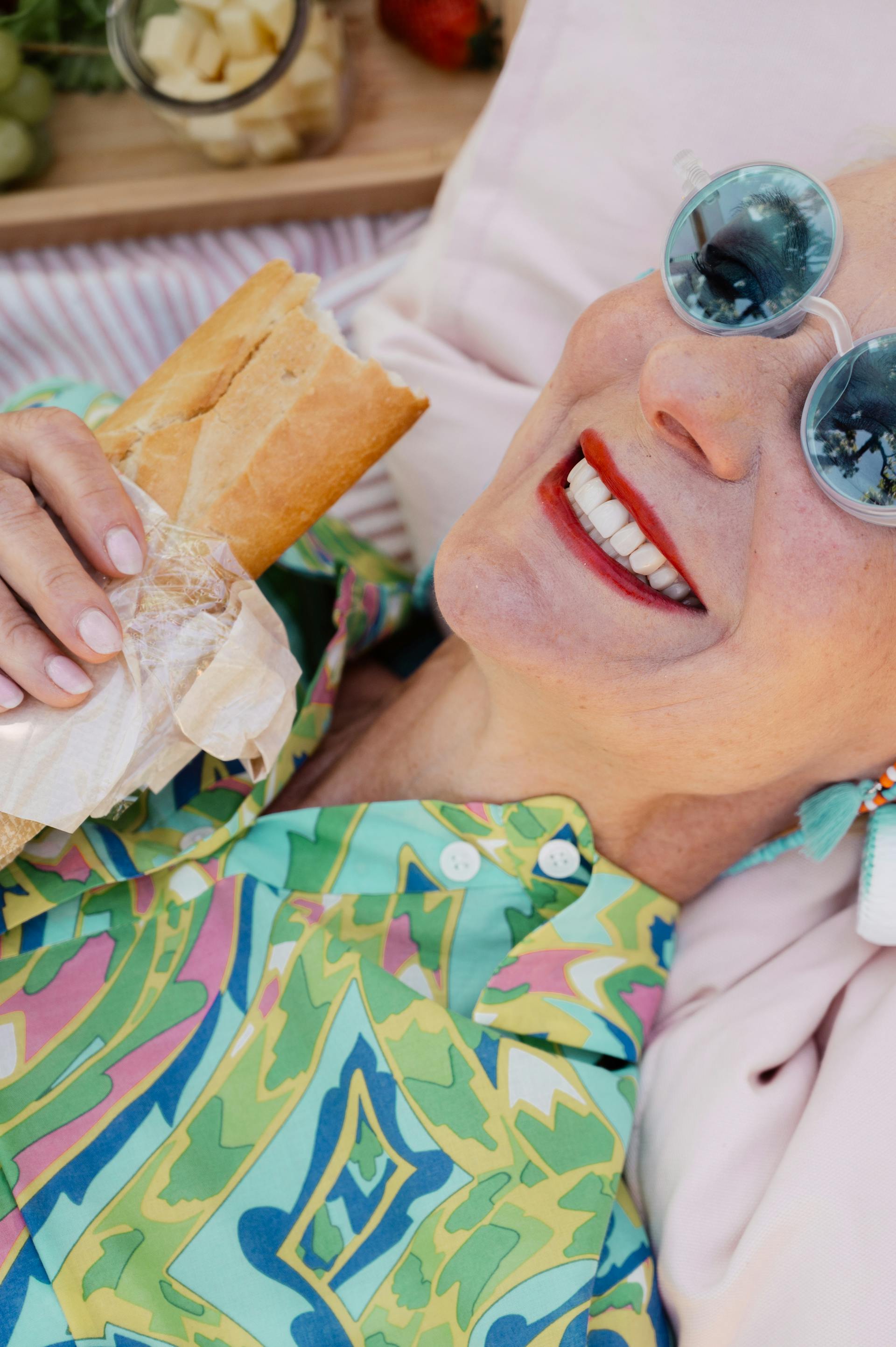 Primer plano de una mujer mayor tumbada mientras sostiene una hogaza de pan | Fuente: Pexels