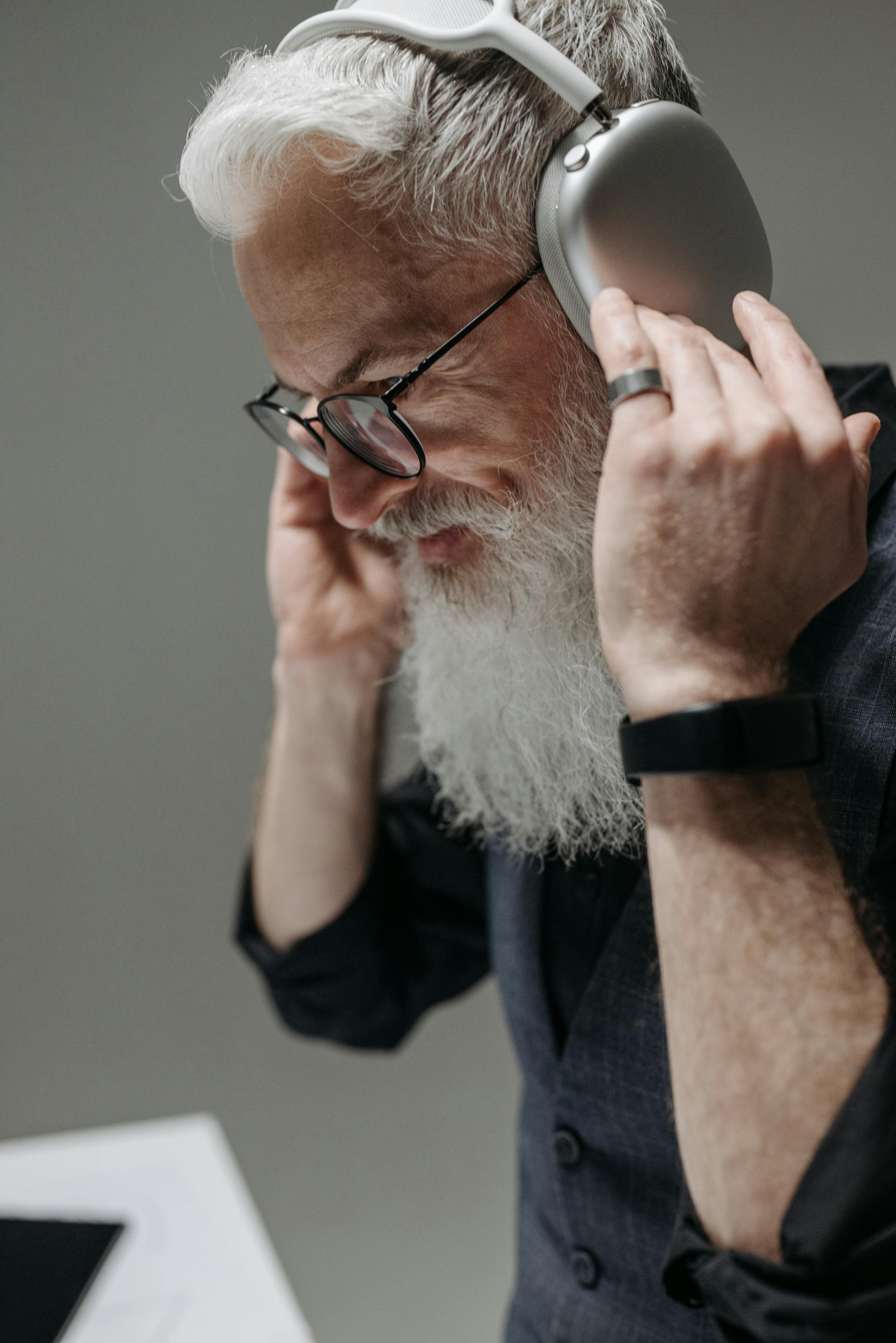 Un hombre mayor sonriente con auriculares | Fuente: Pexels