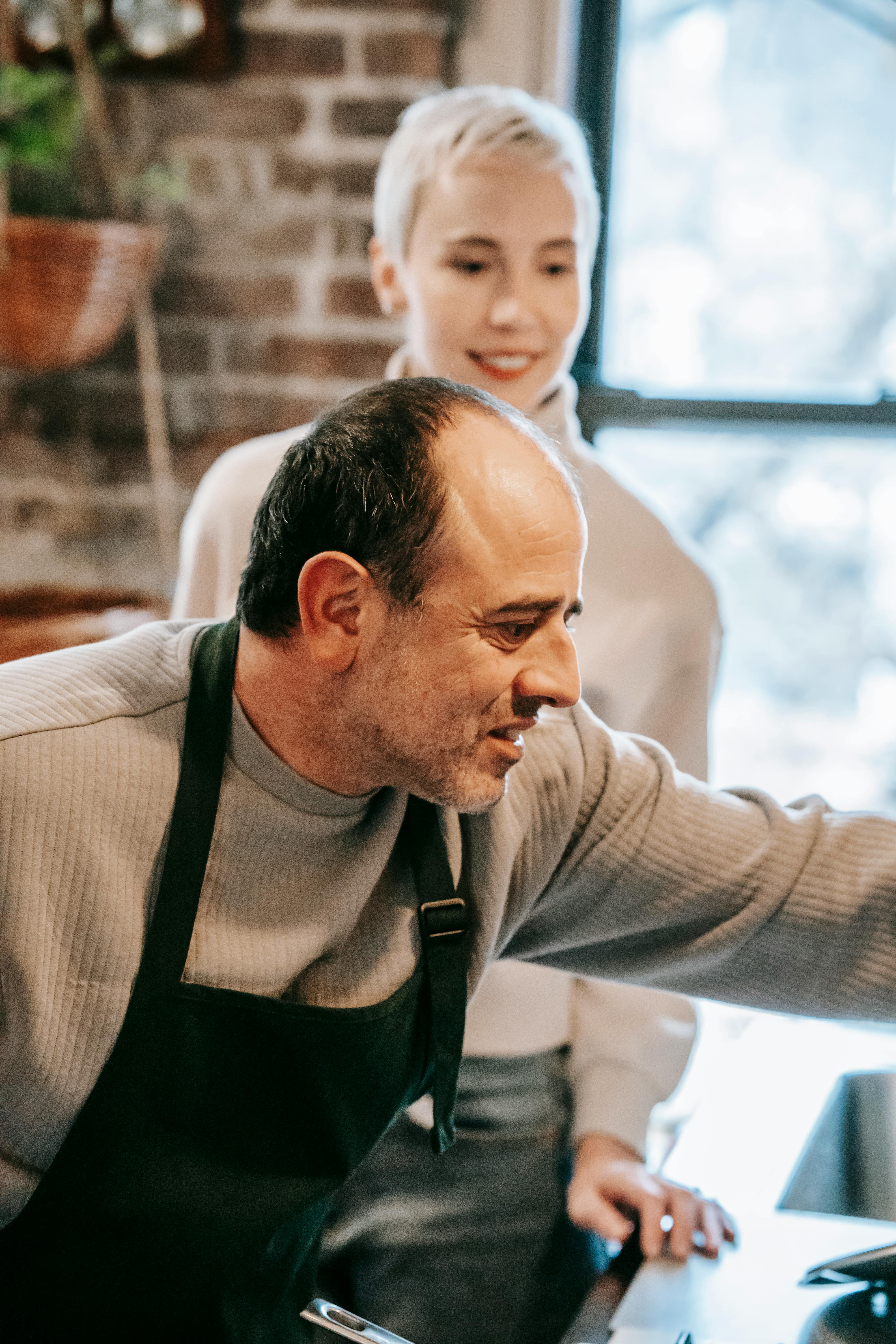 Pareja de mediana edad cocinando | Fuente: Pexels